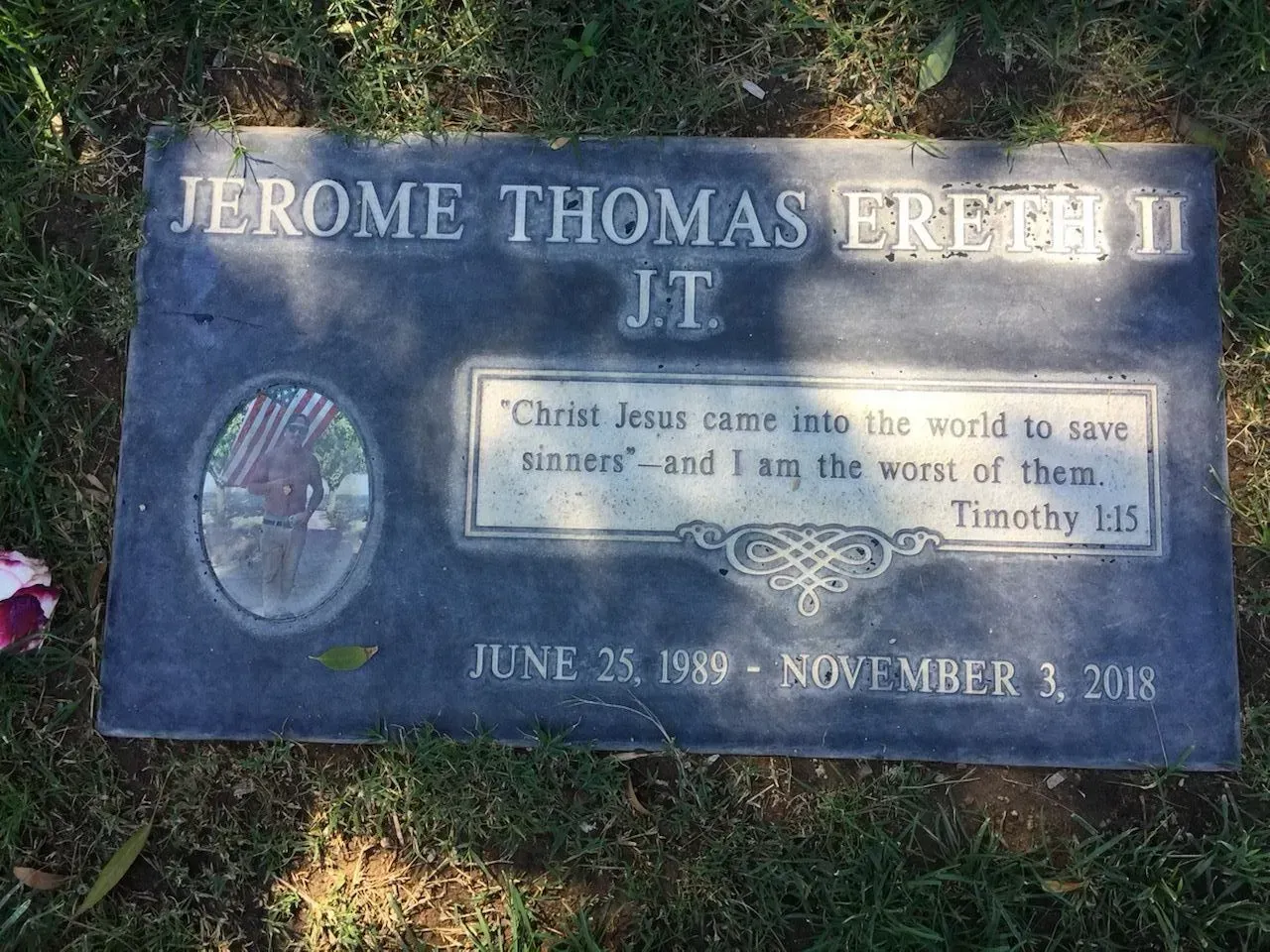 Gray headstone of Jerome Thomas Erfthy II. Includes birth/death dates, a bible verse, and a photo inset.