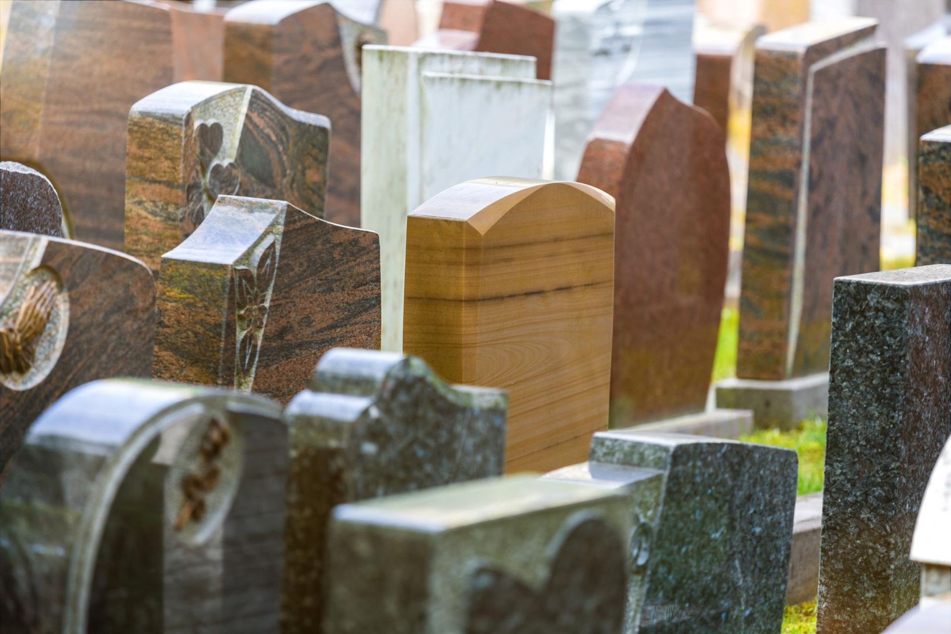 Close-up of a cemetery with various headstones made of different colored granite.