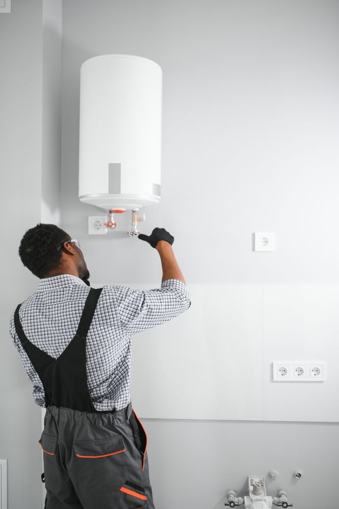 Woman in straw hat smiles, holding wine glass near a lake.