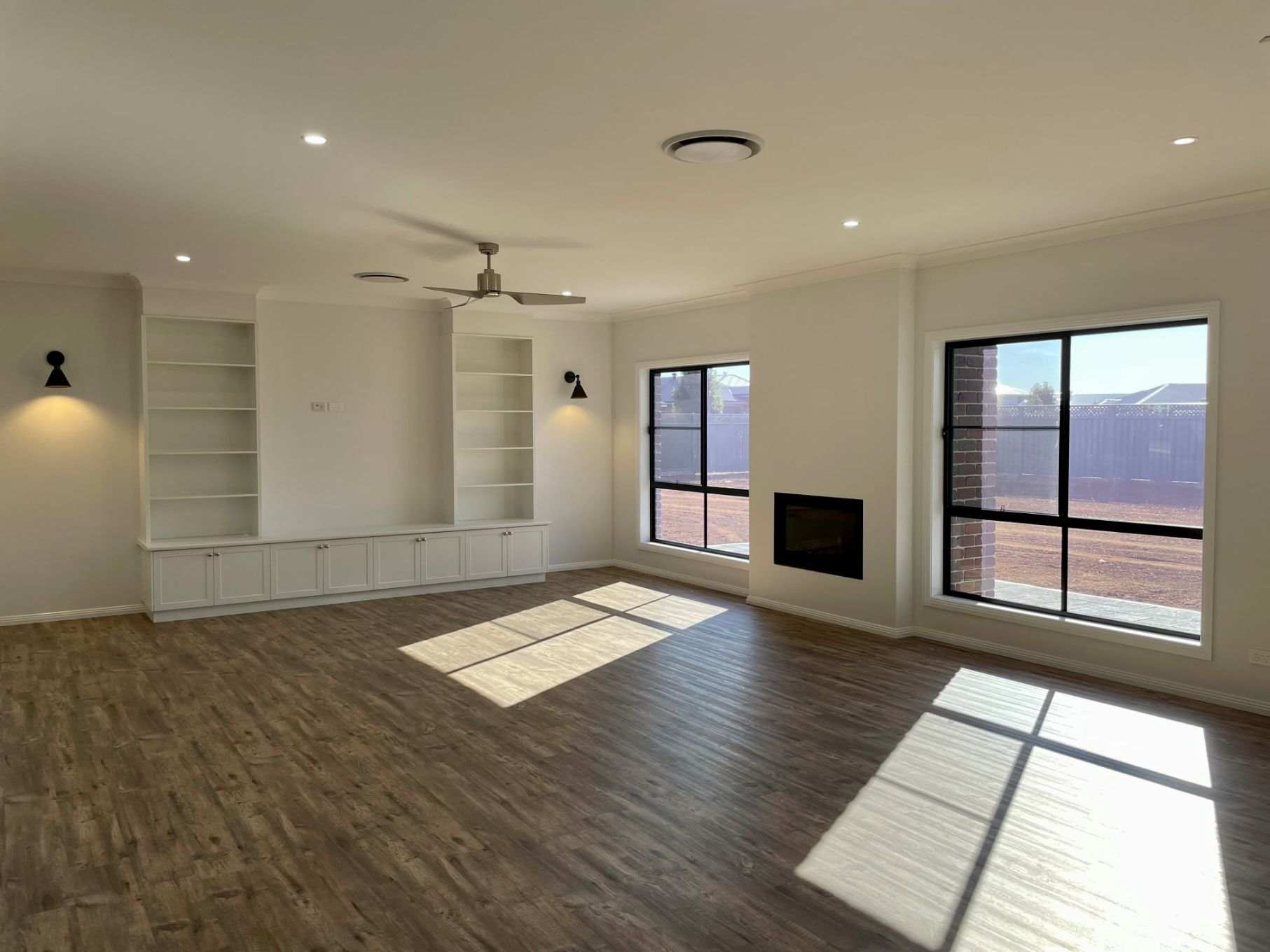 Living Room With Fireplace And Cabinet Shelves — Custom Design Homes in Dubbo, NSW