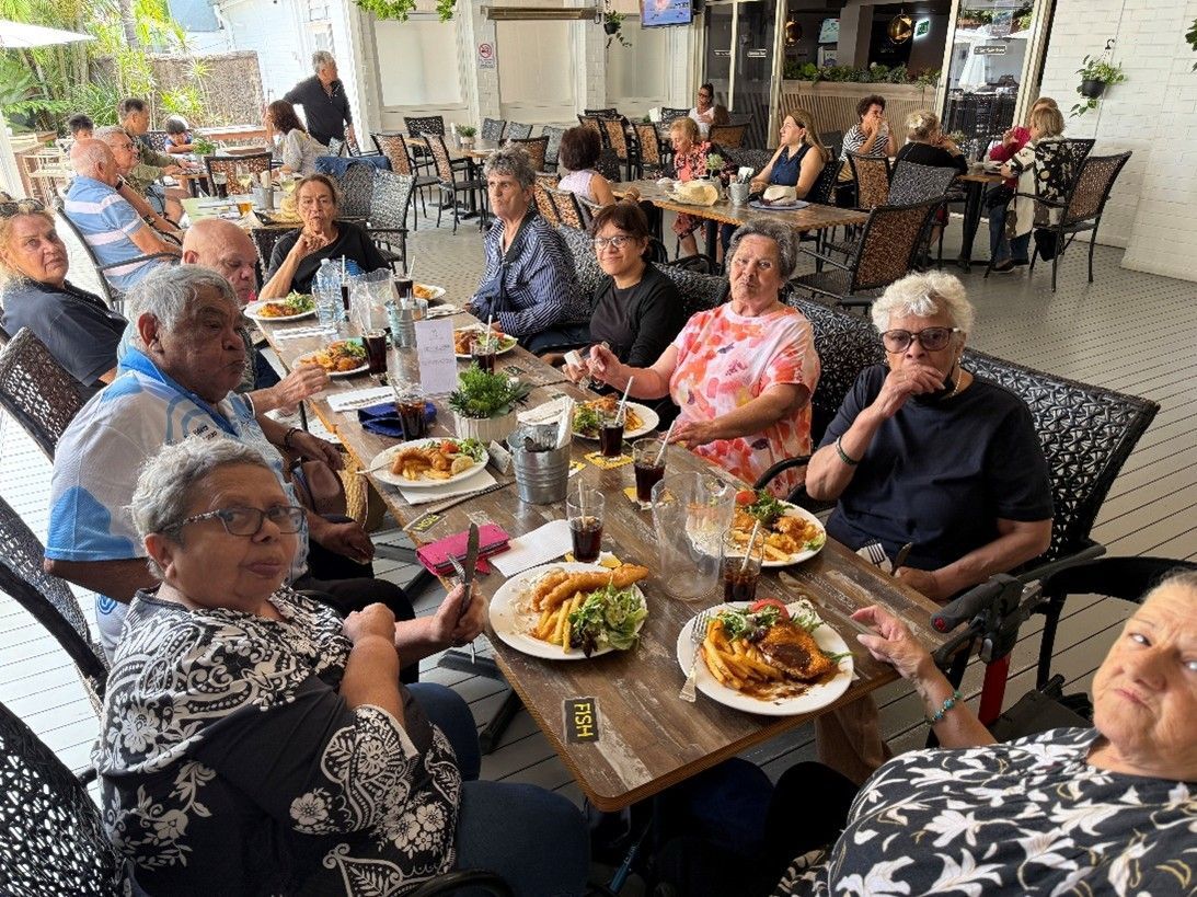 A group of people are sitting at a table eating food.