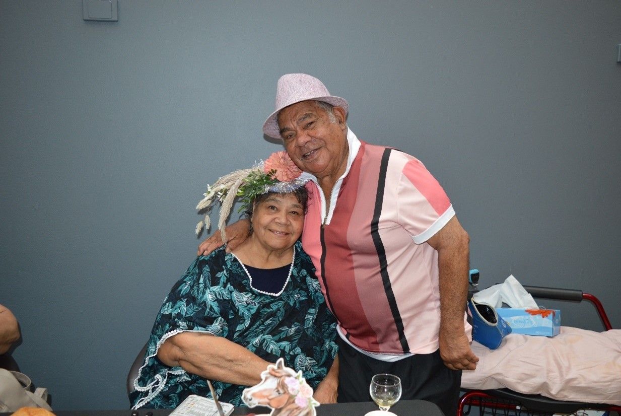 A man and a woman are posing for a picture in a room.