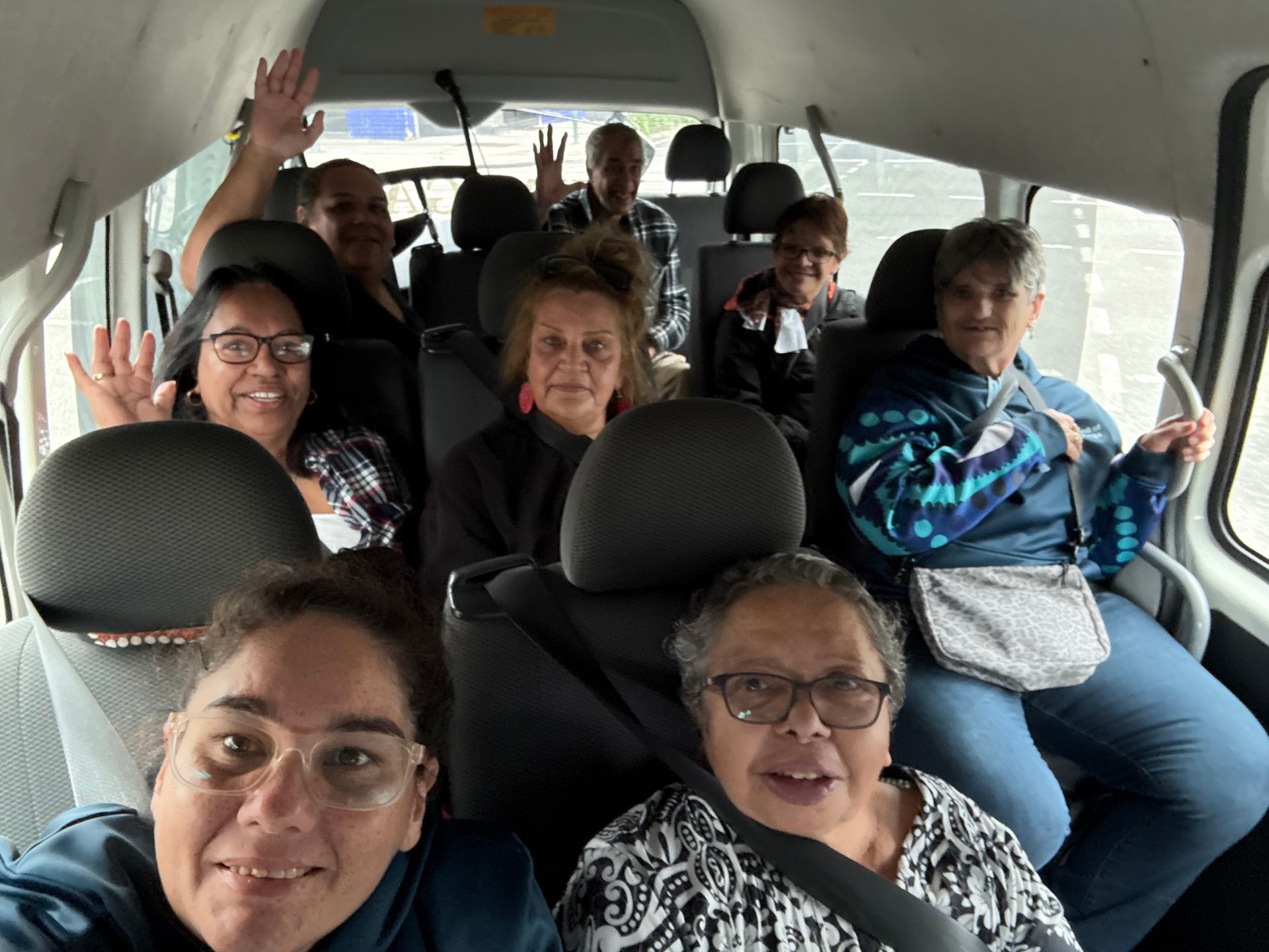 A group of people are sitting in the back seat of a van.