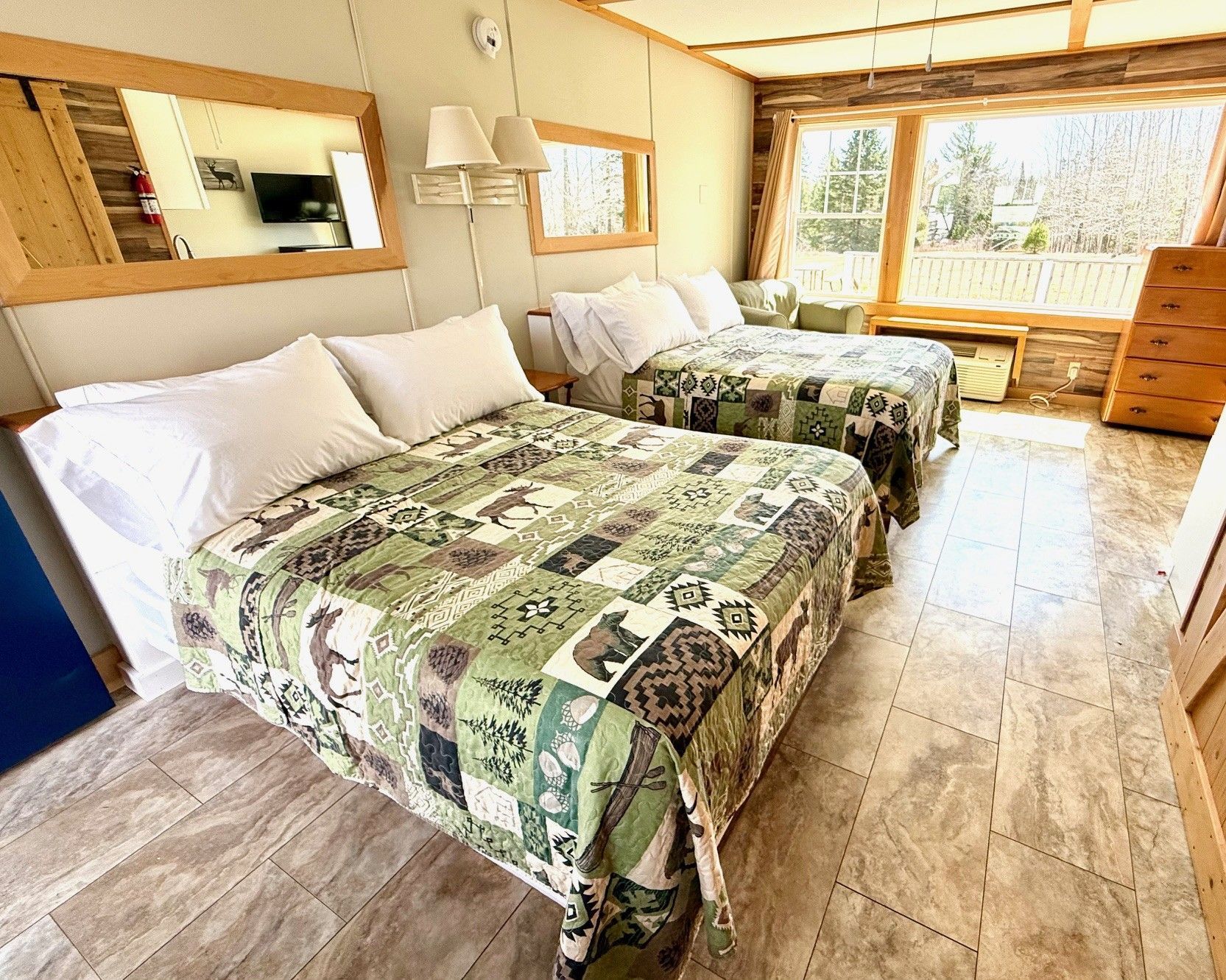 A hotel room with two beds and a large window.