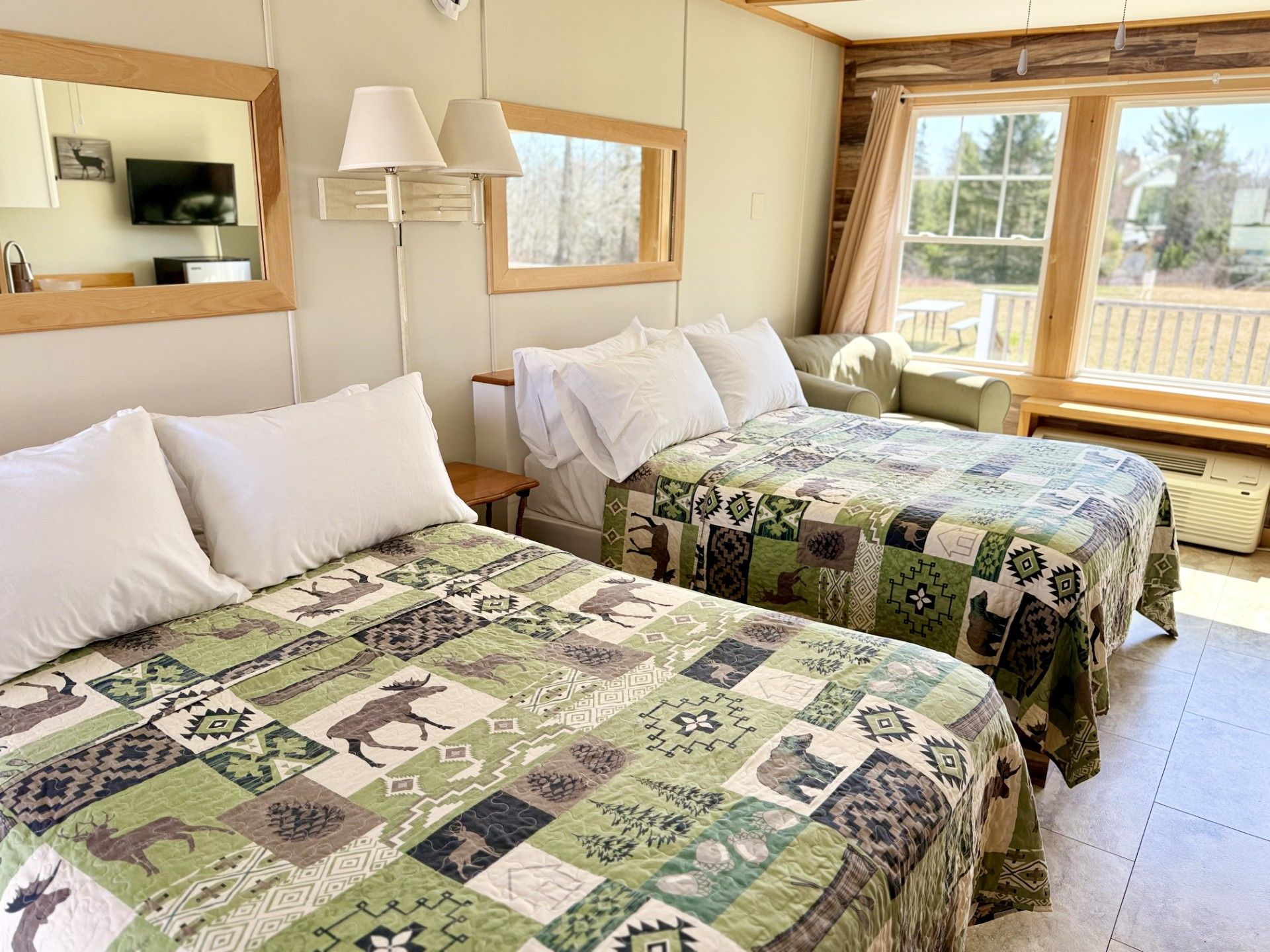A hotel room with two beds and a large window.