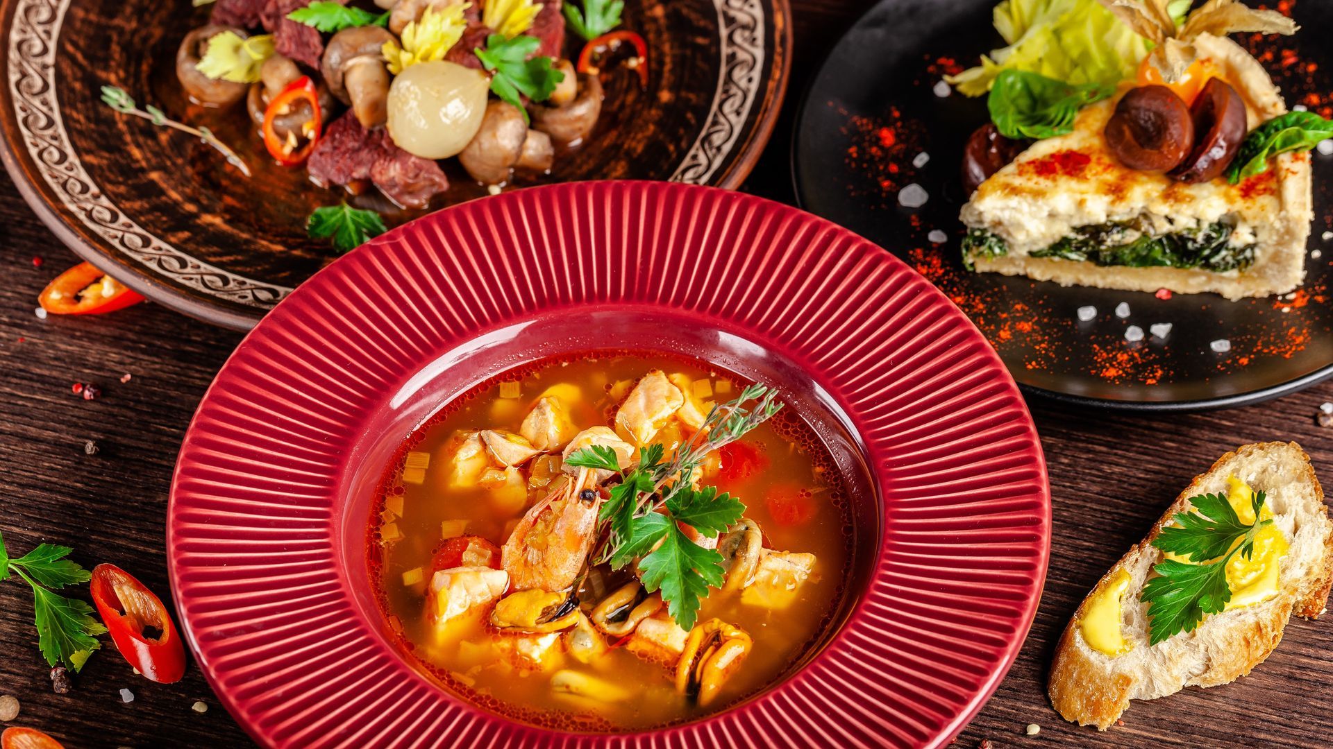 A table topped with plates of food and a bowl of soup.