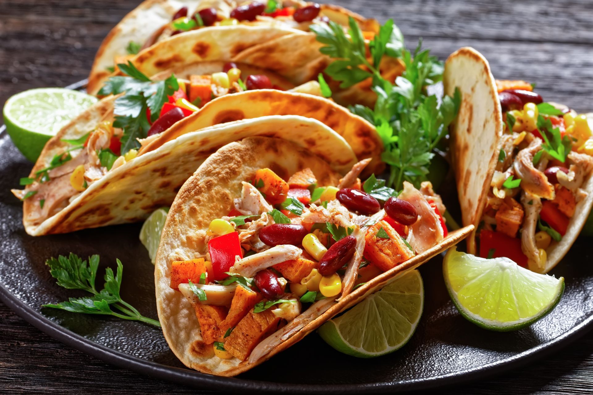 A close up of a plate of tacos on a wooden table.