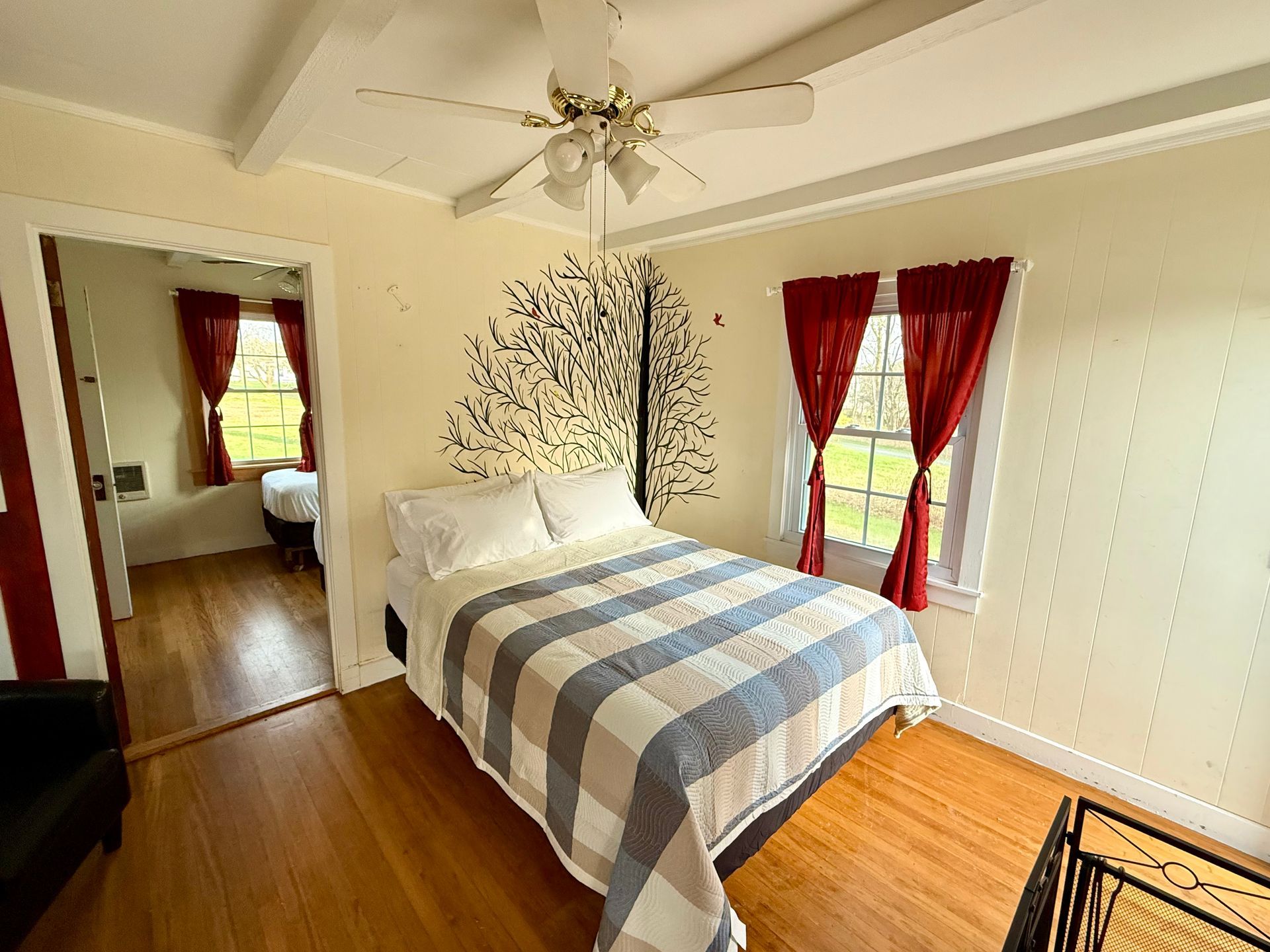 A bedroom with a bed and a ceiling fan
