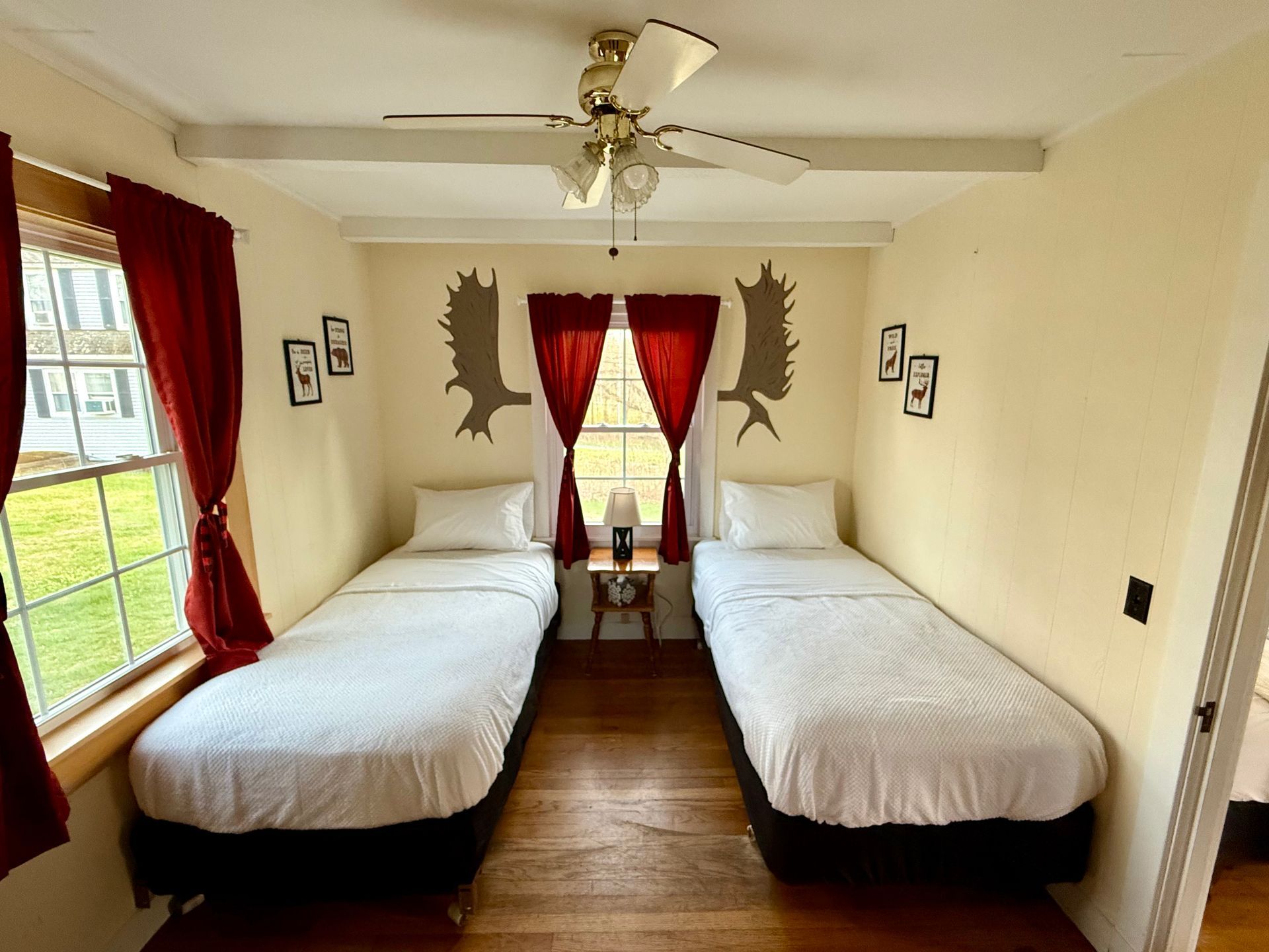 A bedroom with two beds and a ceiling fan