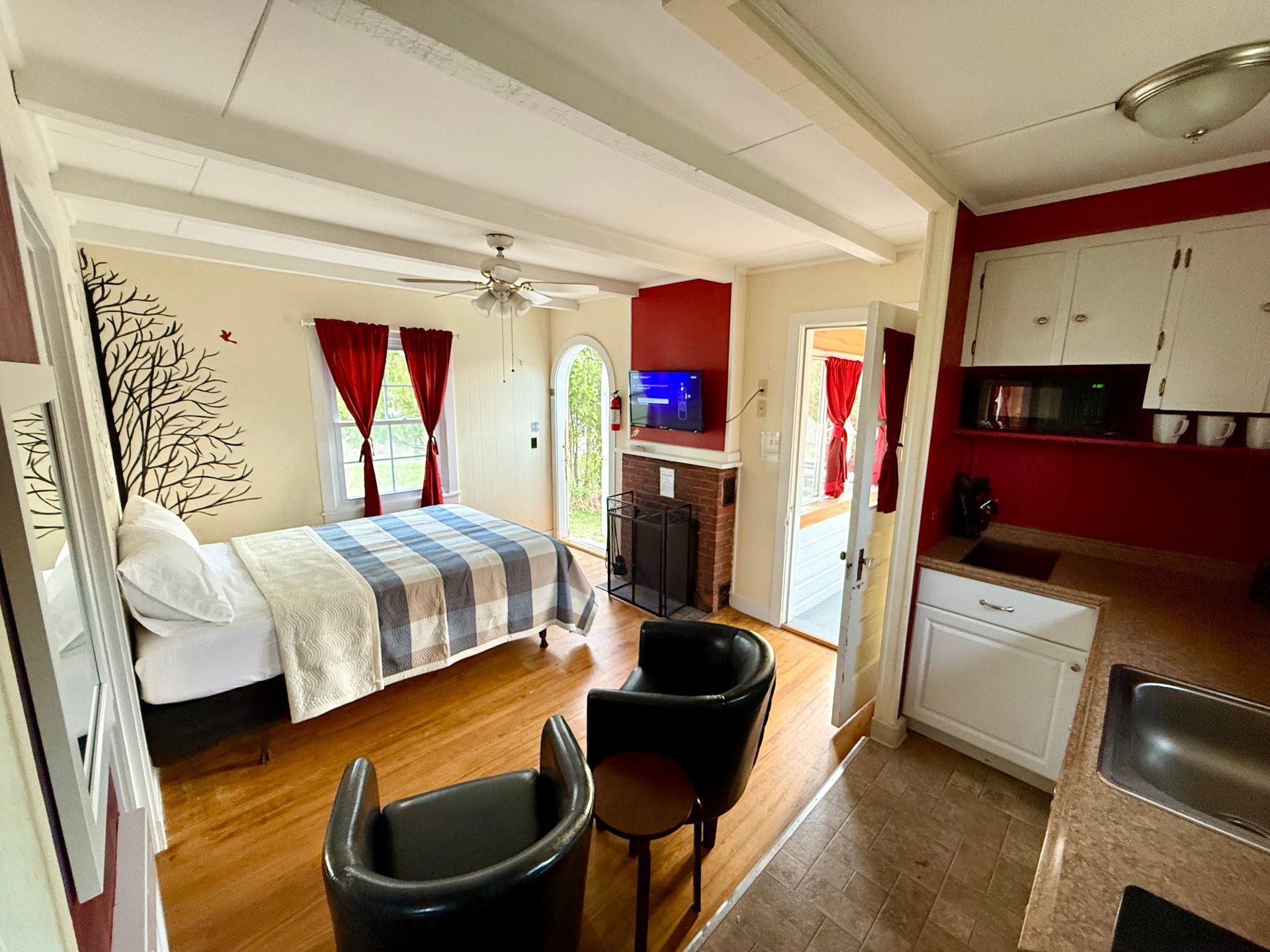 A bedroom with a bed , chairs , and a fireplace.