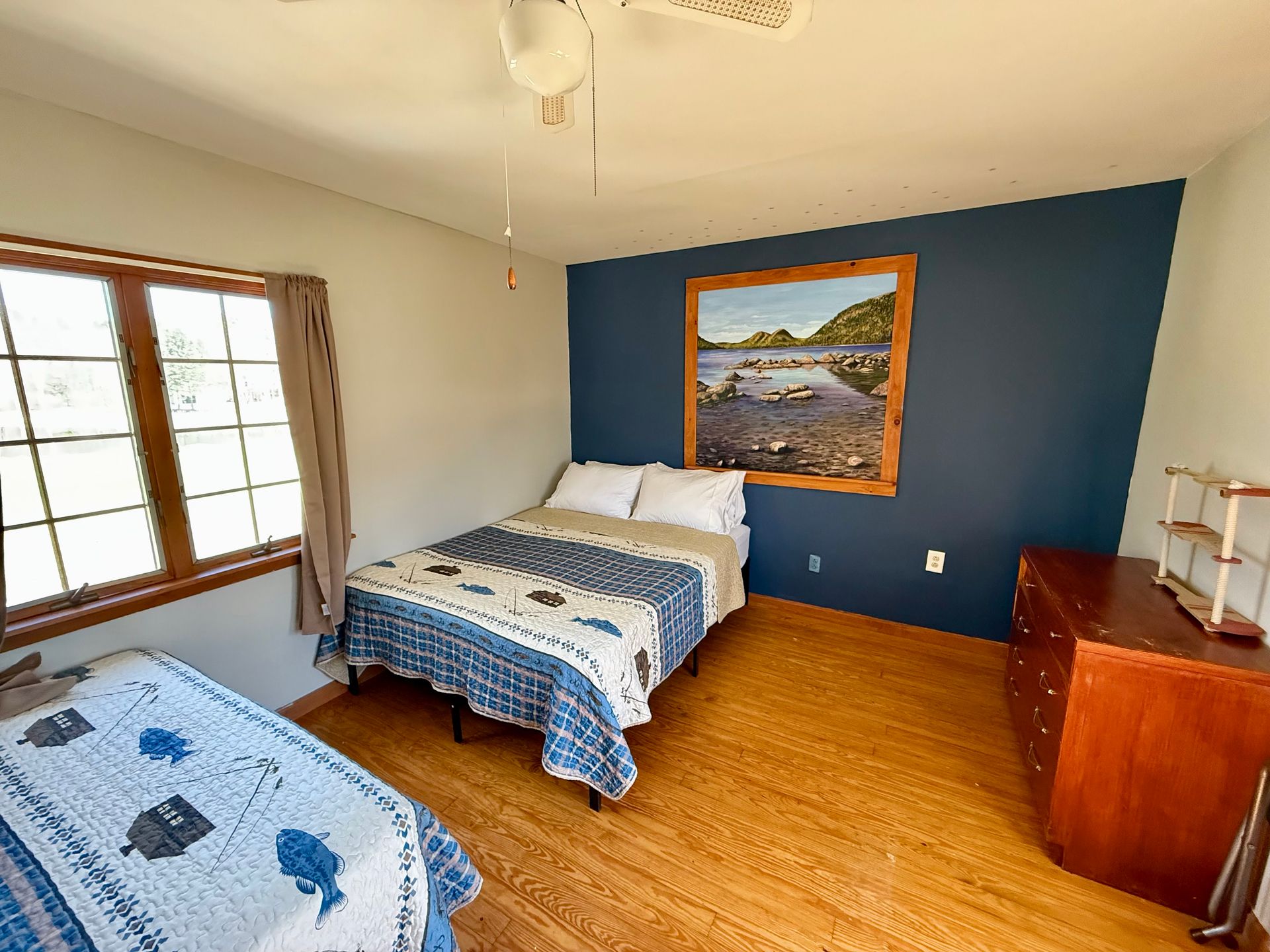 A bedroom with two beds and a picture on the wall