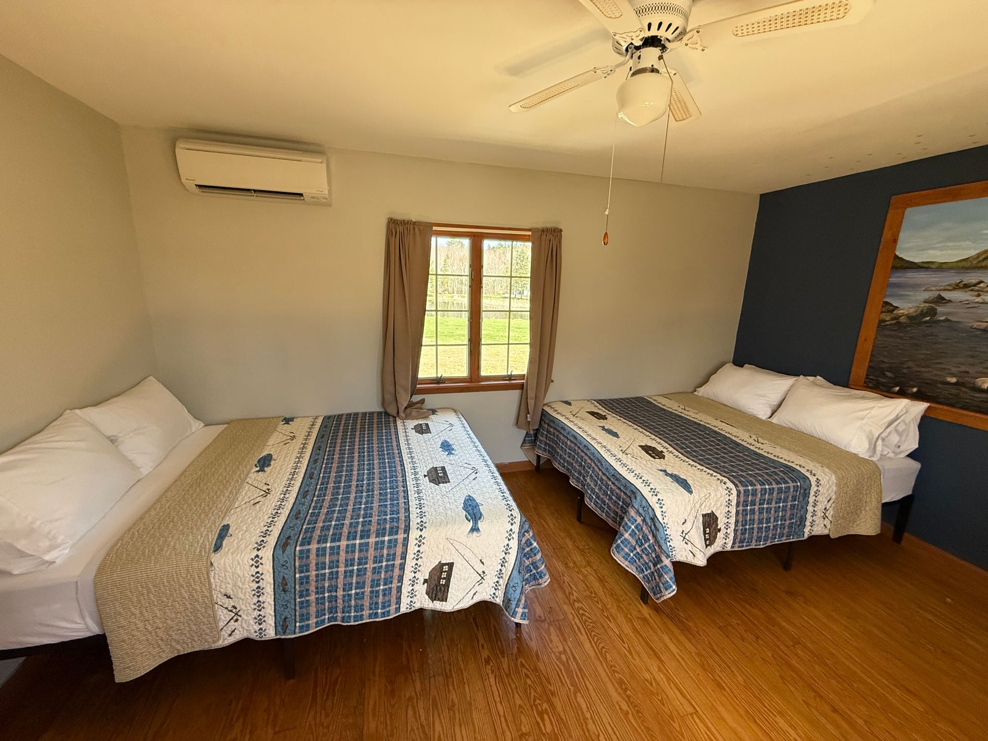 A bedroom with two beds and a ceiling fan