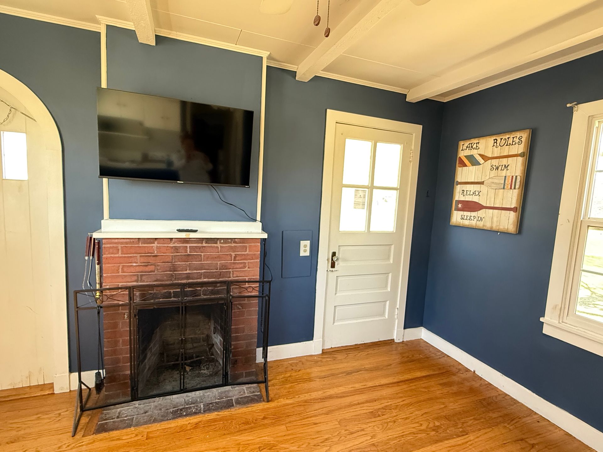 A living room with a fireplace and a flat screen tv