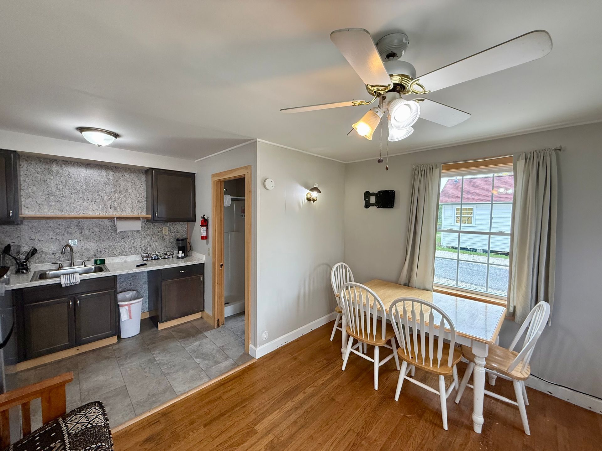 A dining room with a table and chairs and a ceiling fan.