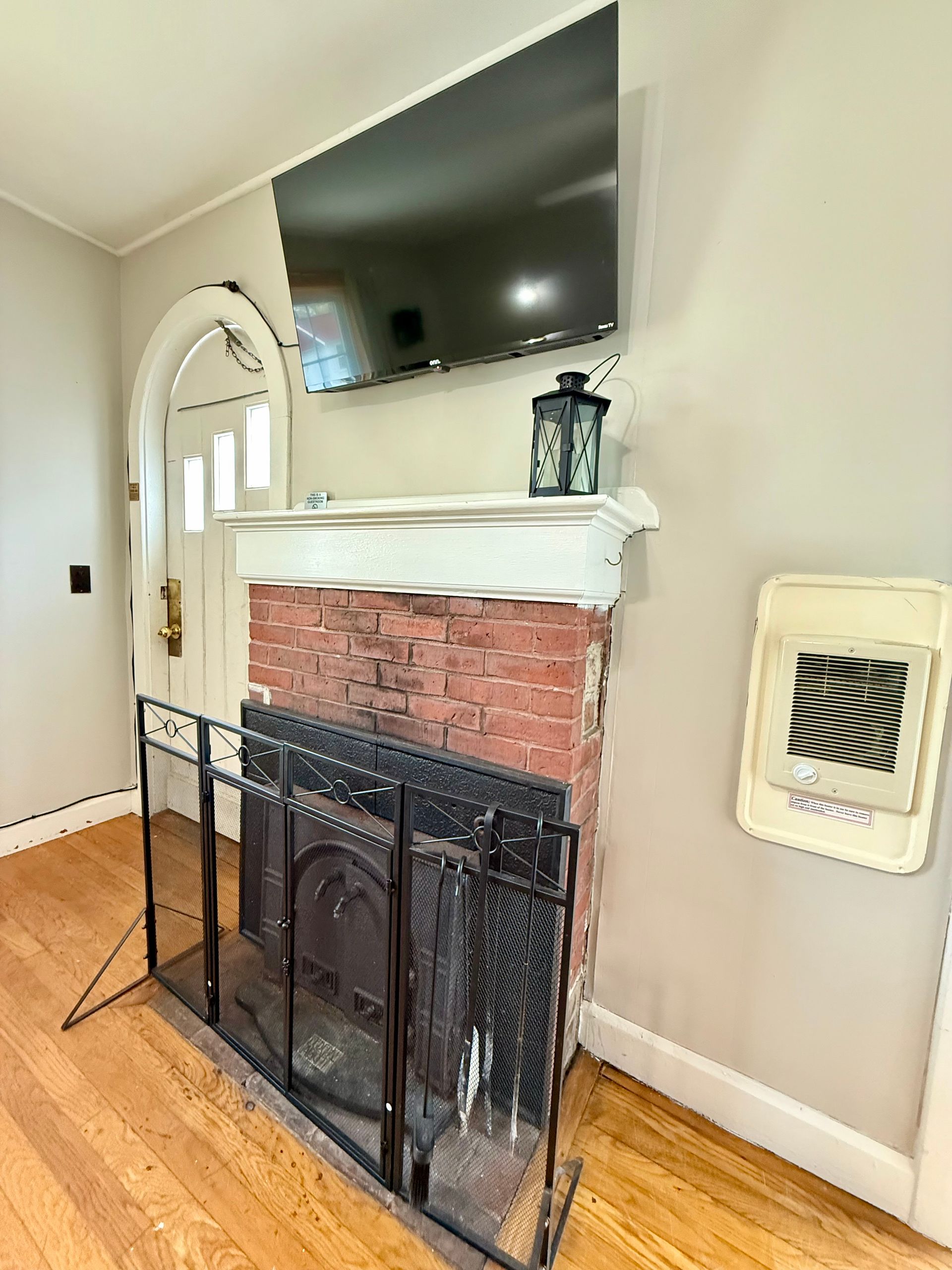 A living room with a fireplace and a flat screen tv.