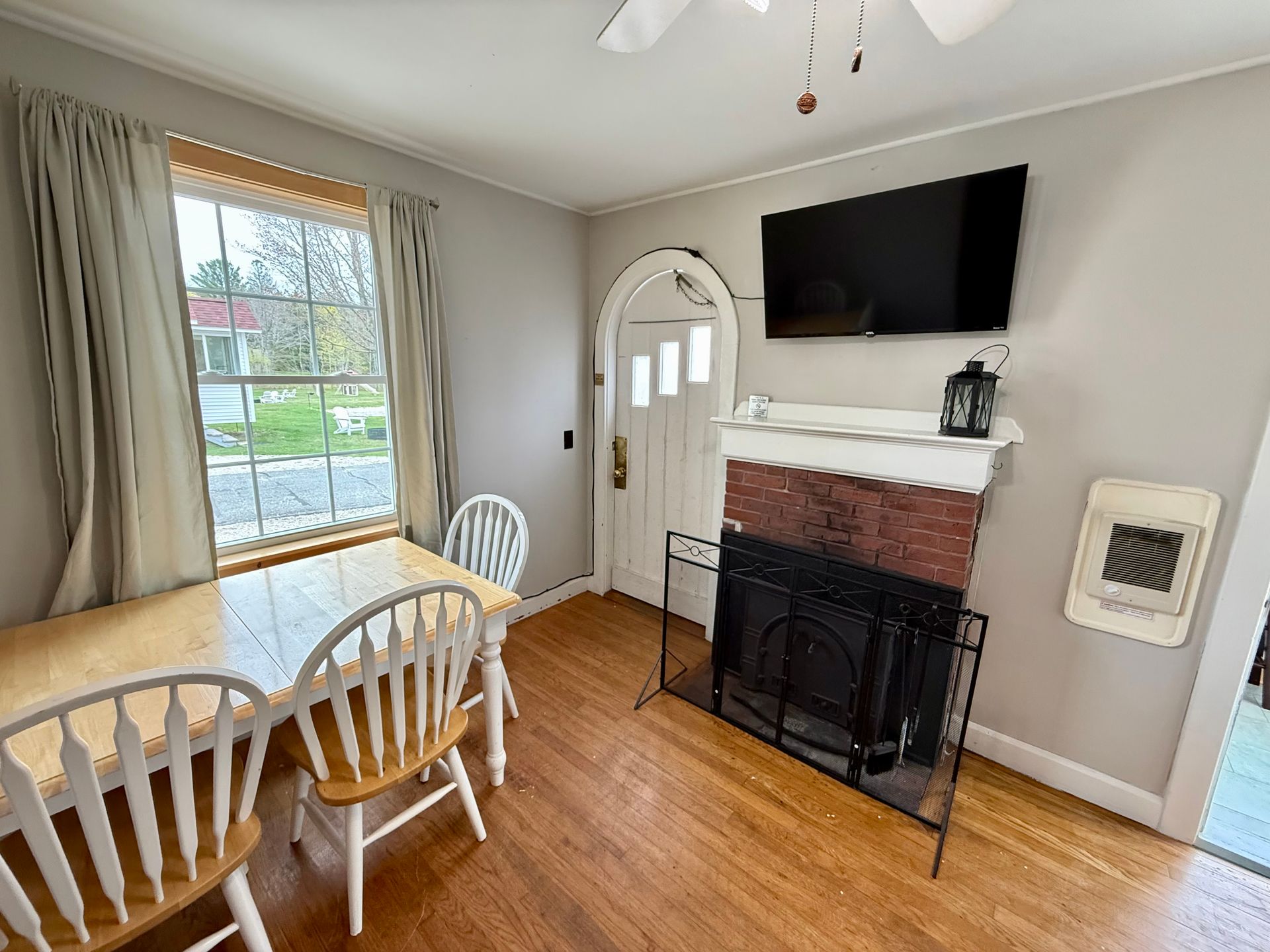 A living room with a fireplace , table and chairs.