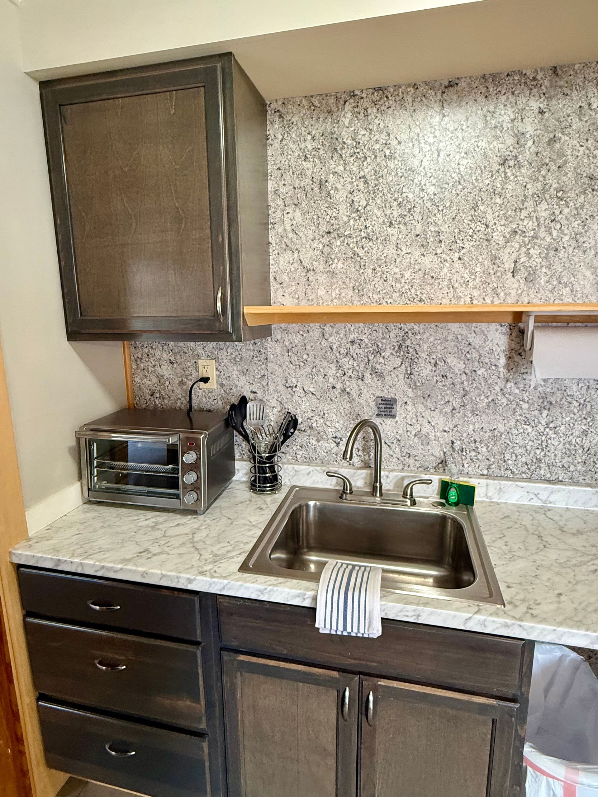 A kitchen with a sink and a toaster oven