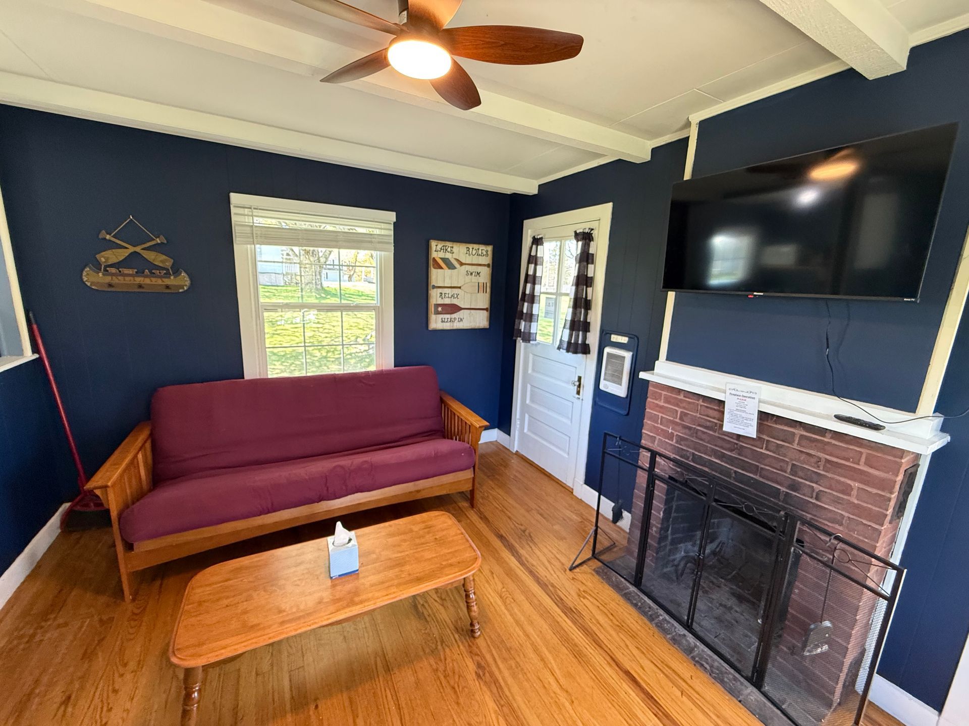 A living room with a fireplace , couch , coffee table and television.