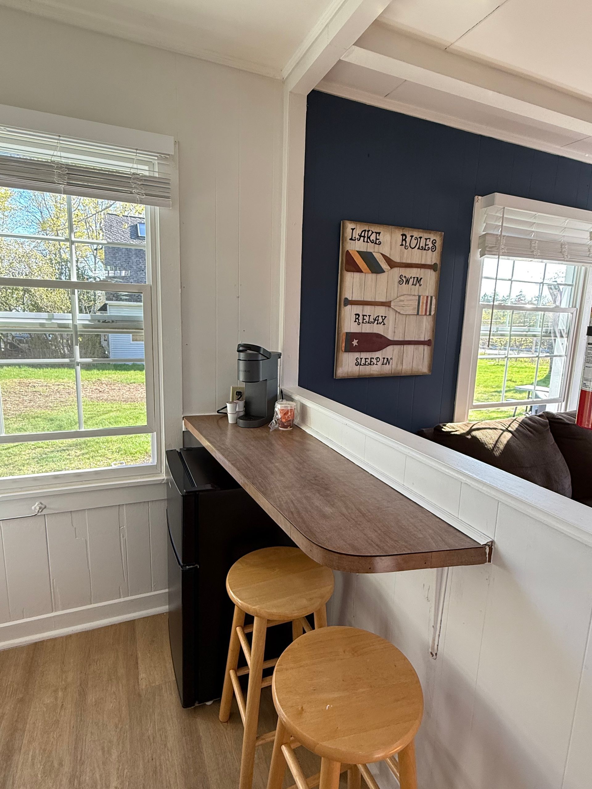 A kitchen with a long wooden table and two stools.