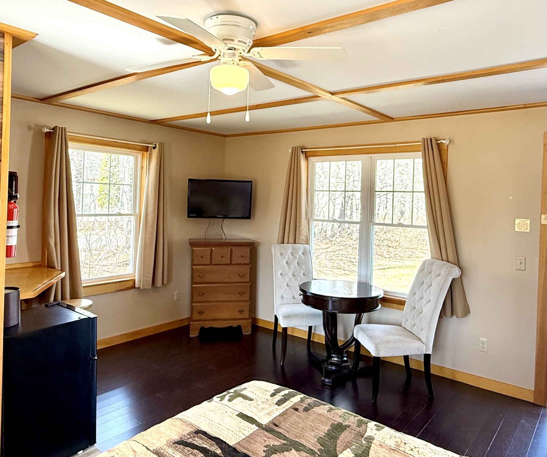 A living room with a table and chairs and a flat screen tv.