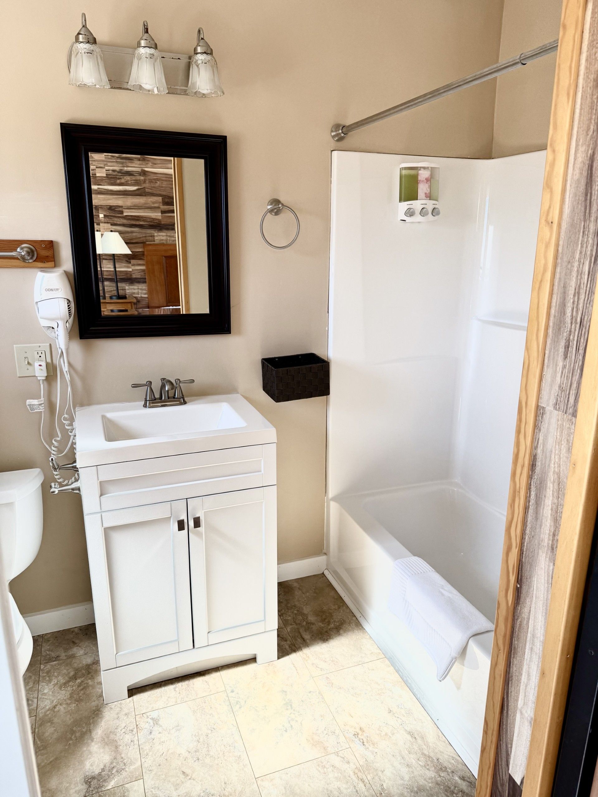 A bathroom with a sink , tub and mirror