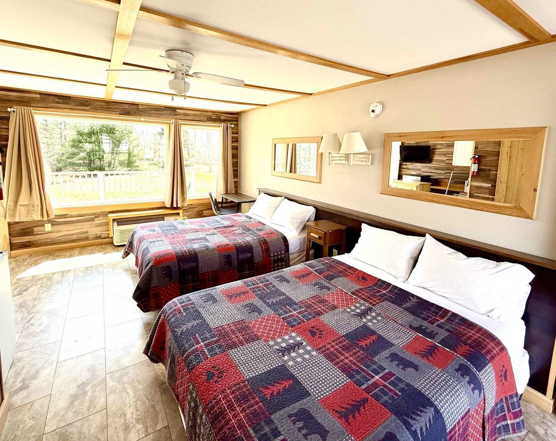 A hotel room with two beds and a large window.