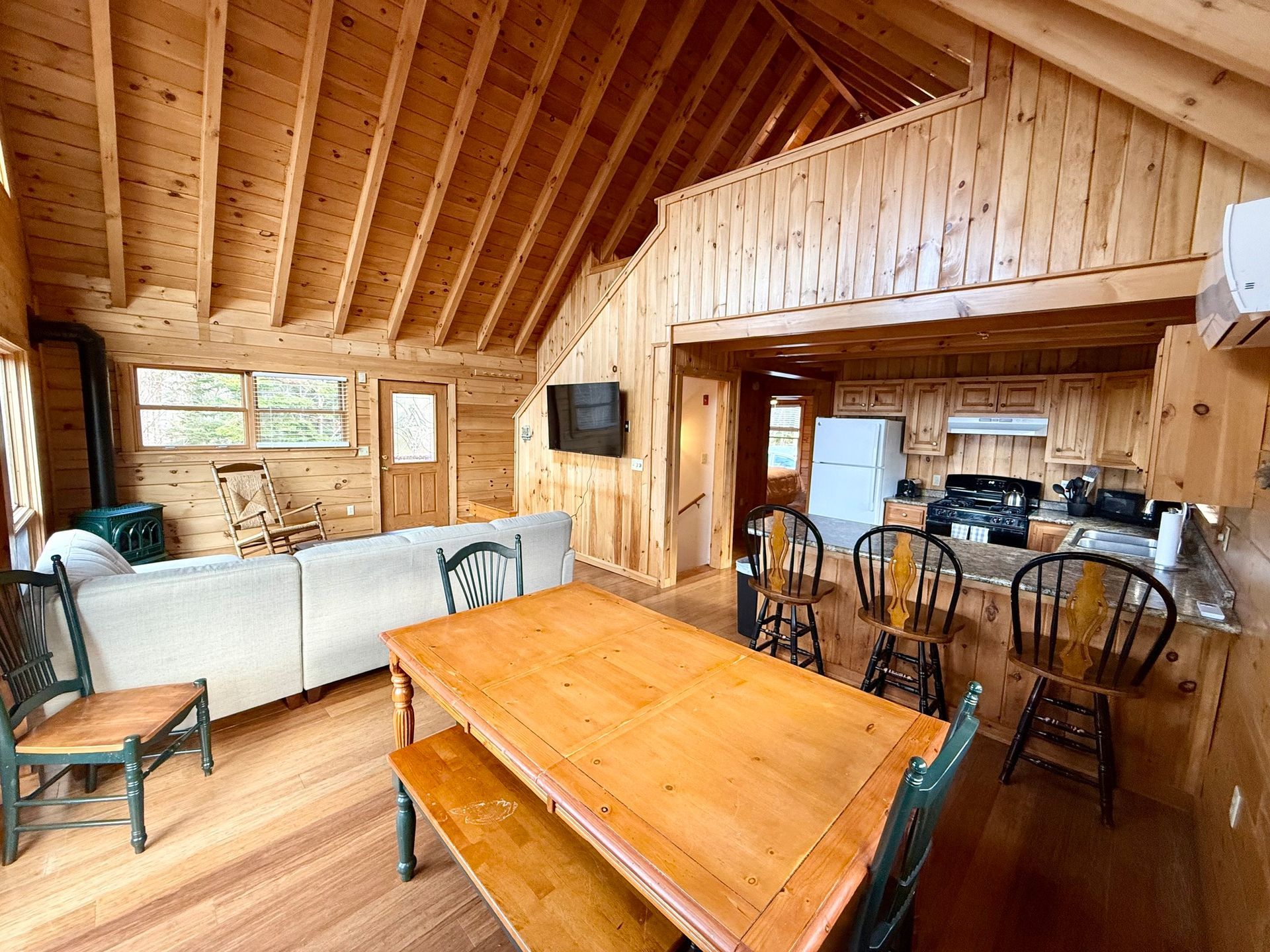 A porch with white rocking chairs and blue doors