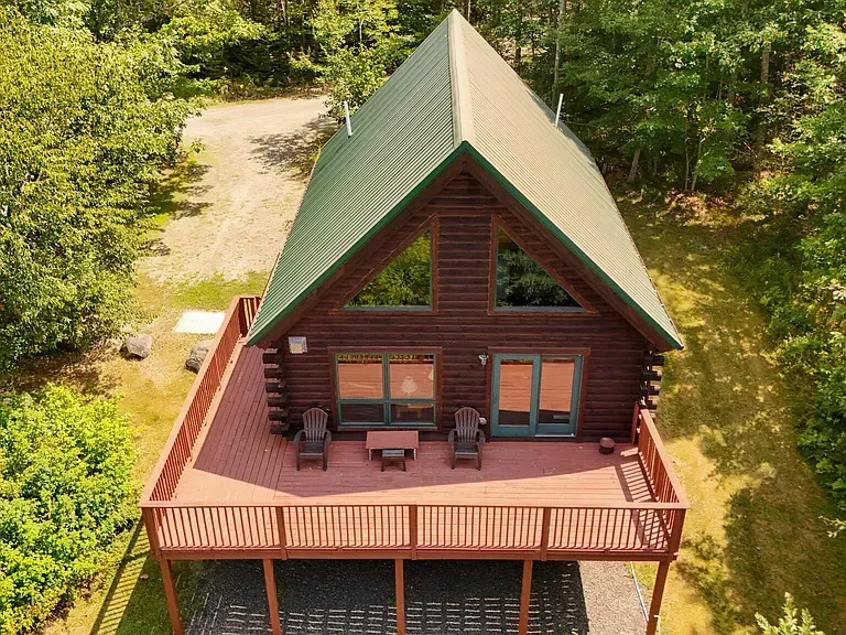 A black lantern is hanging on the side of a white house.