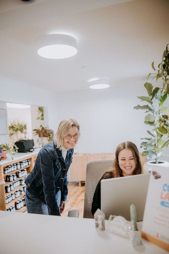 Julie works with a client looking at a computer.