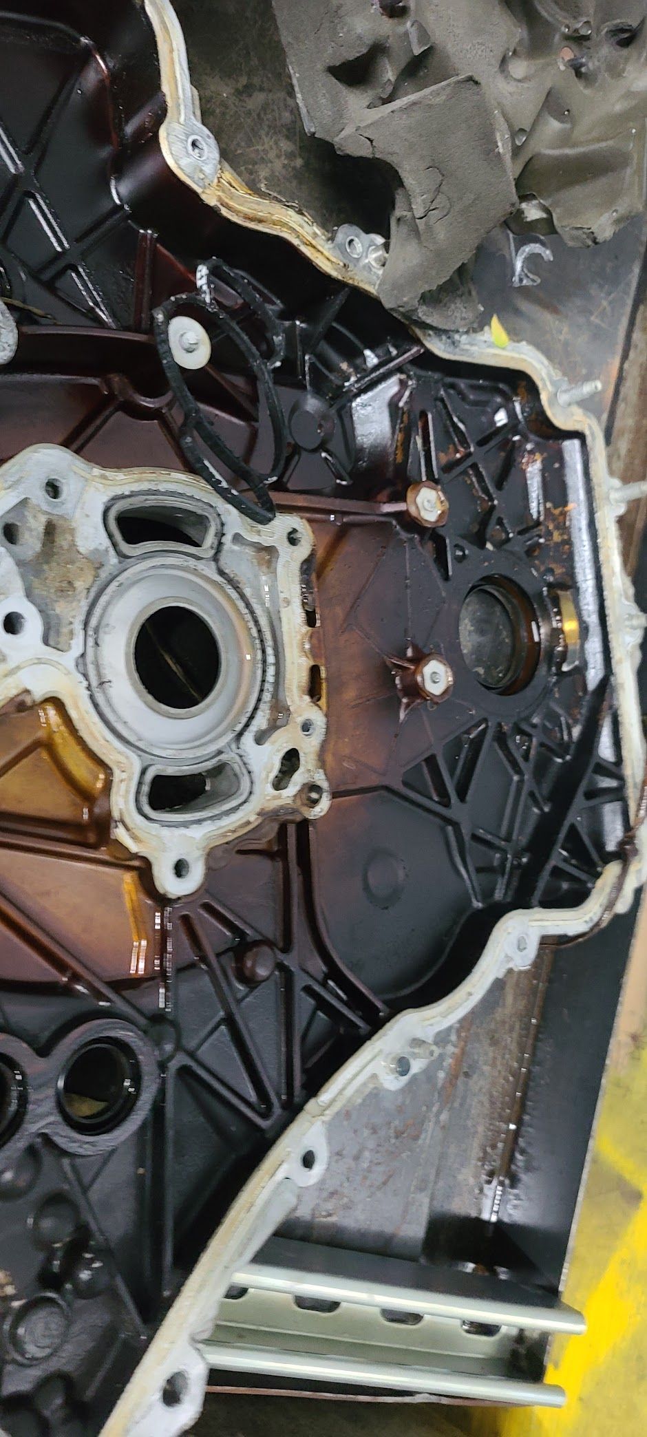 Close-up of a car engine component with oil stains.