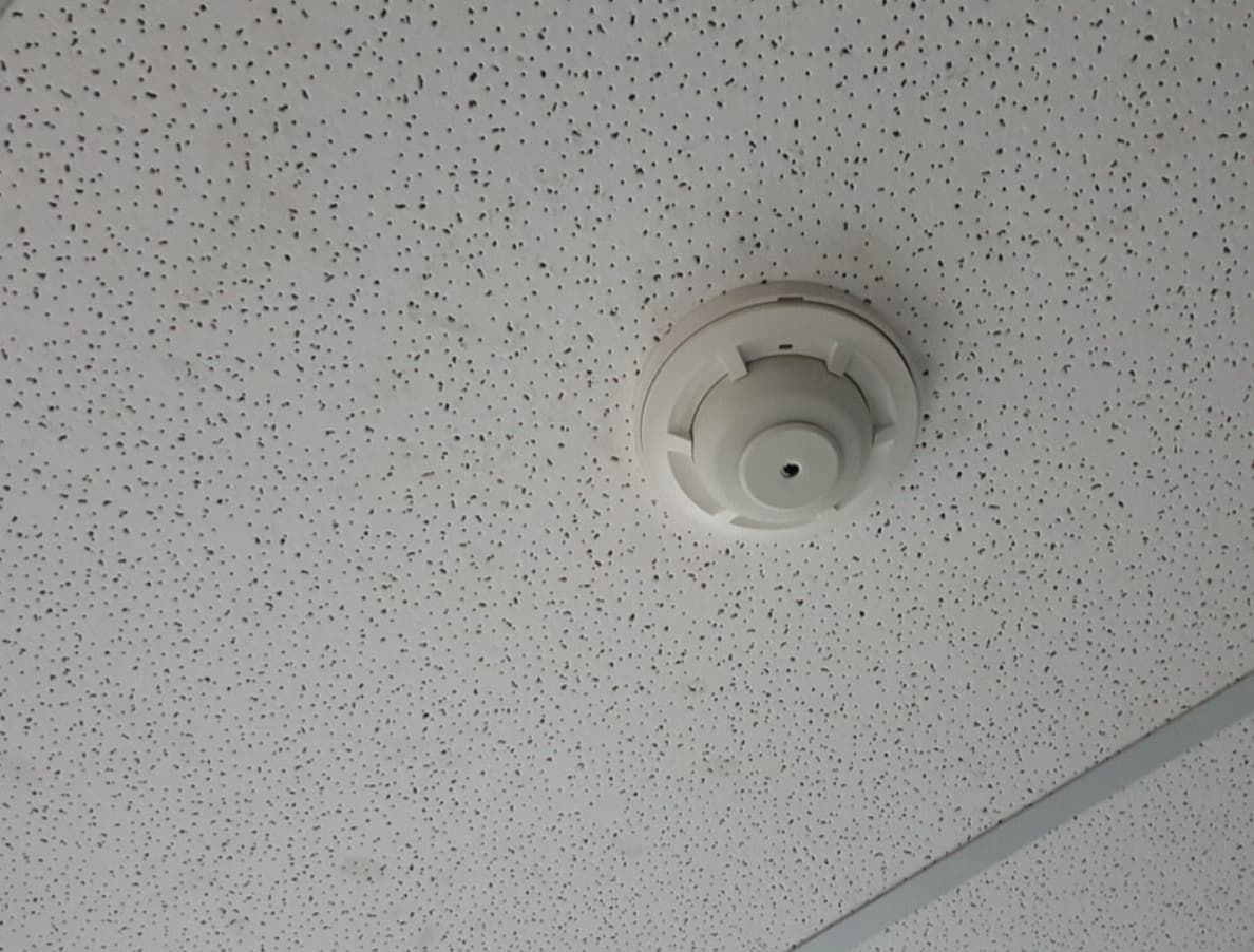 A White Smoke Detector Is Mounted To A White Ceiling — Mozzlec Electrical In Urangan, QLD