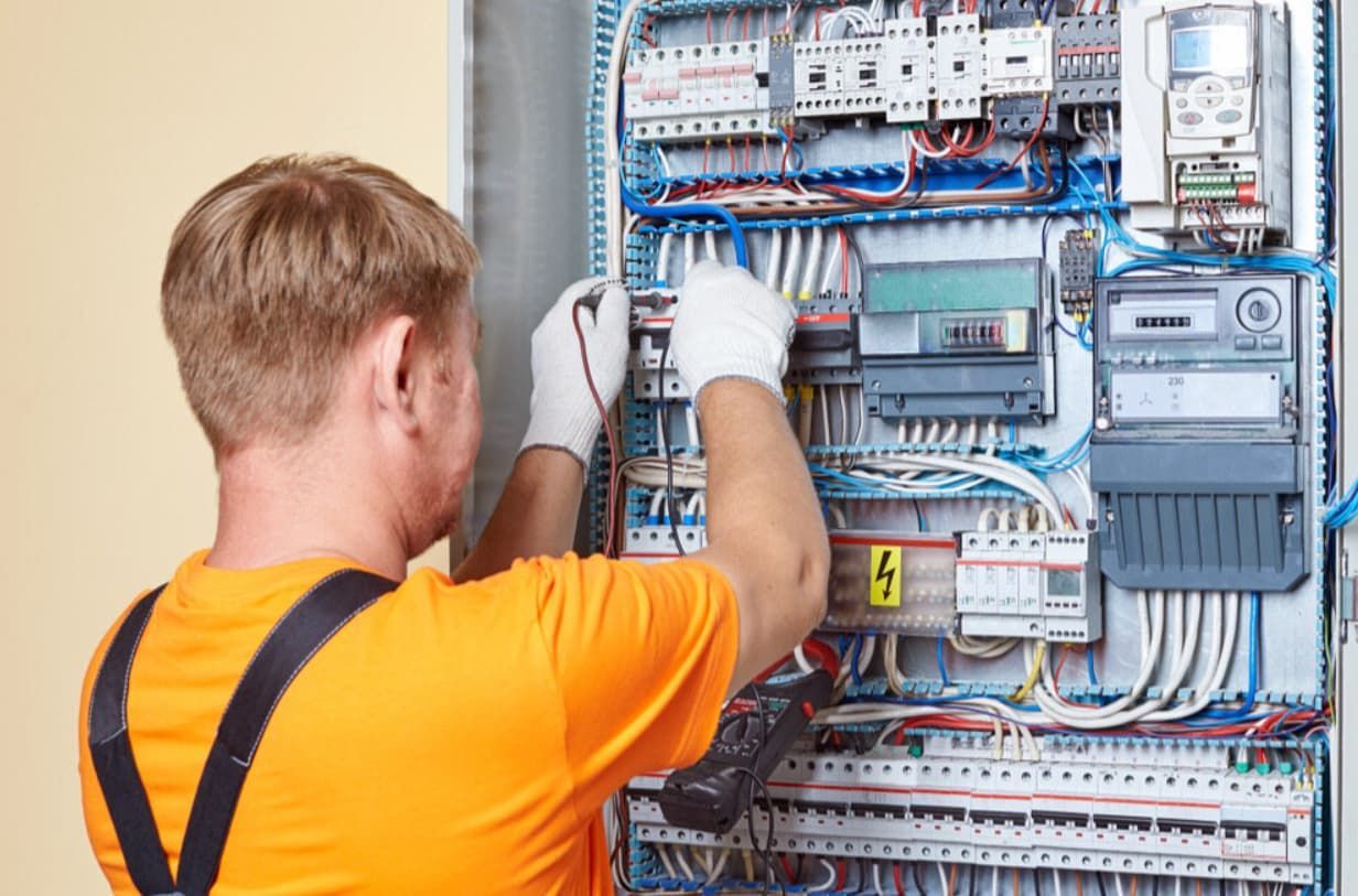 An Electrician Is Working On An Electrical Panel — Mozzlec Electrical In Urangan, QLD