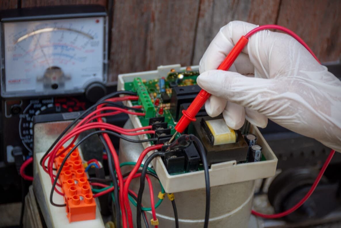 A Person Is Using A Multimeter To Test A Circuit Board — Mozzlec Electrical In Urangan, QLD