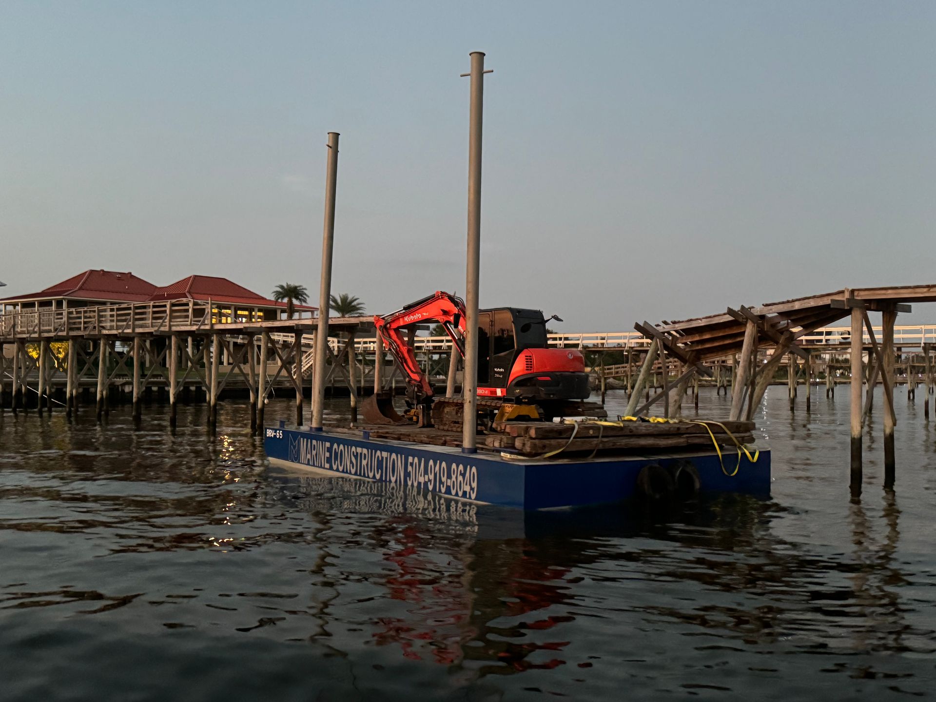 An excavator is on a floating platform in the water
