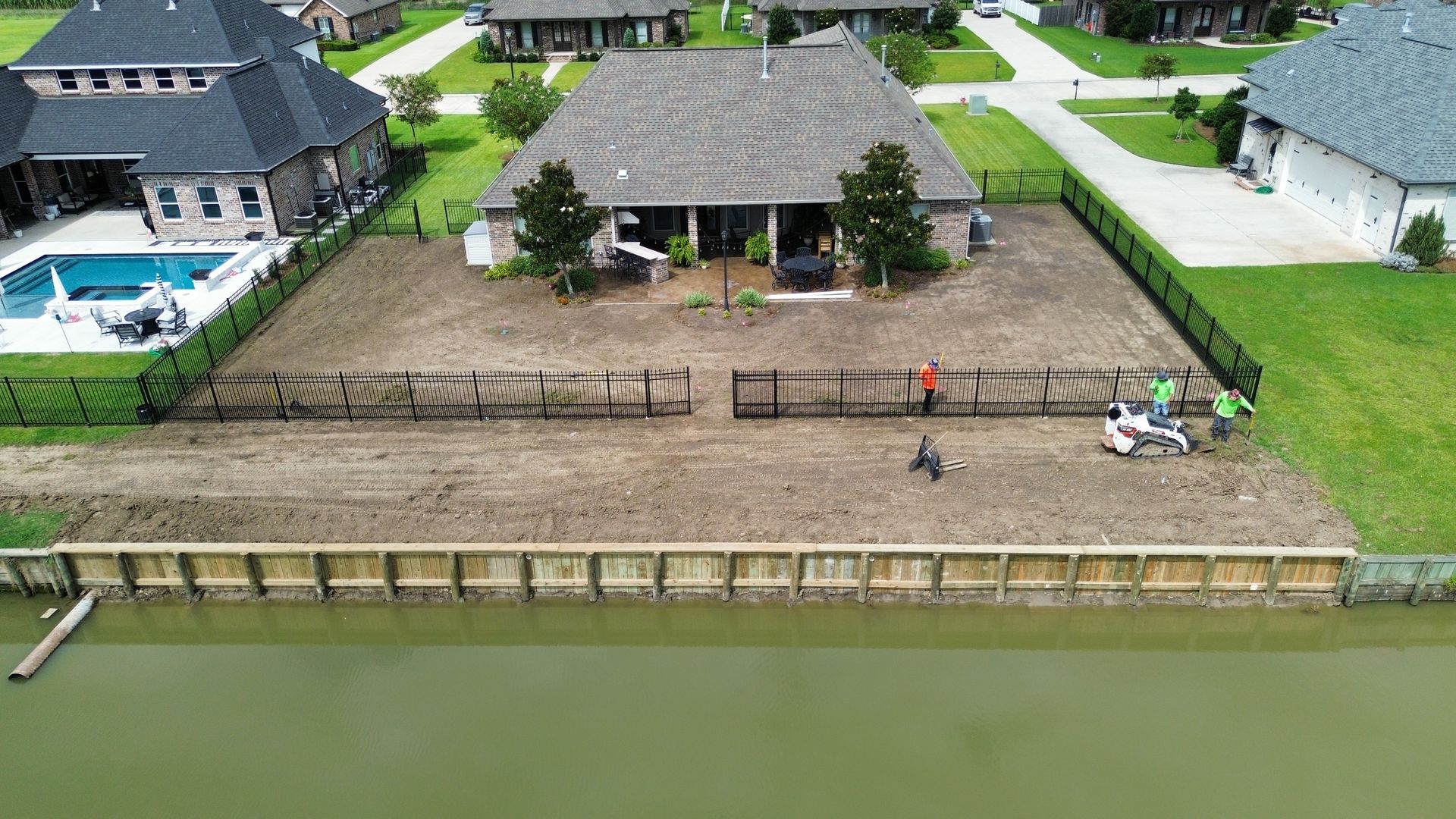 An aerial view of a house with a pool in the backyard.