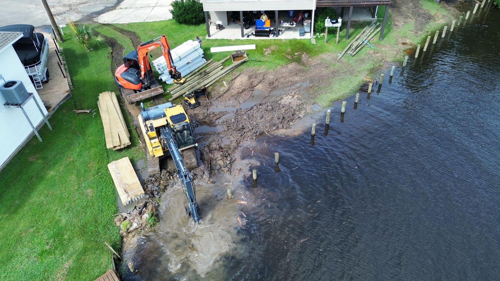An aerial view of a house being built next to a body of water.