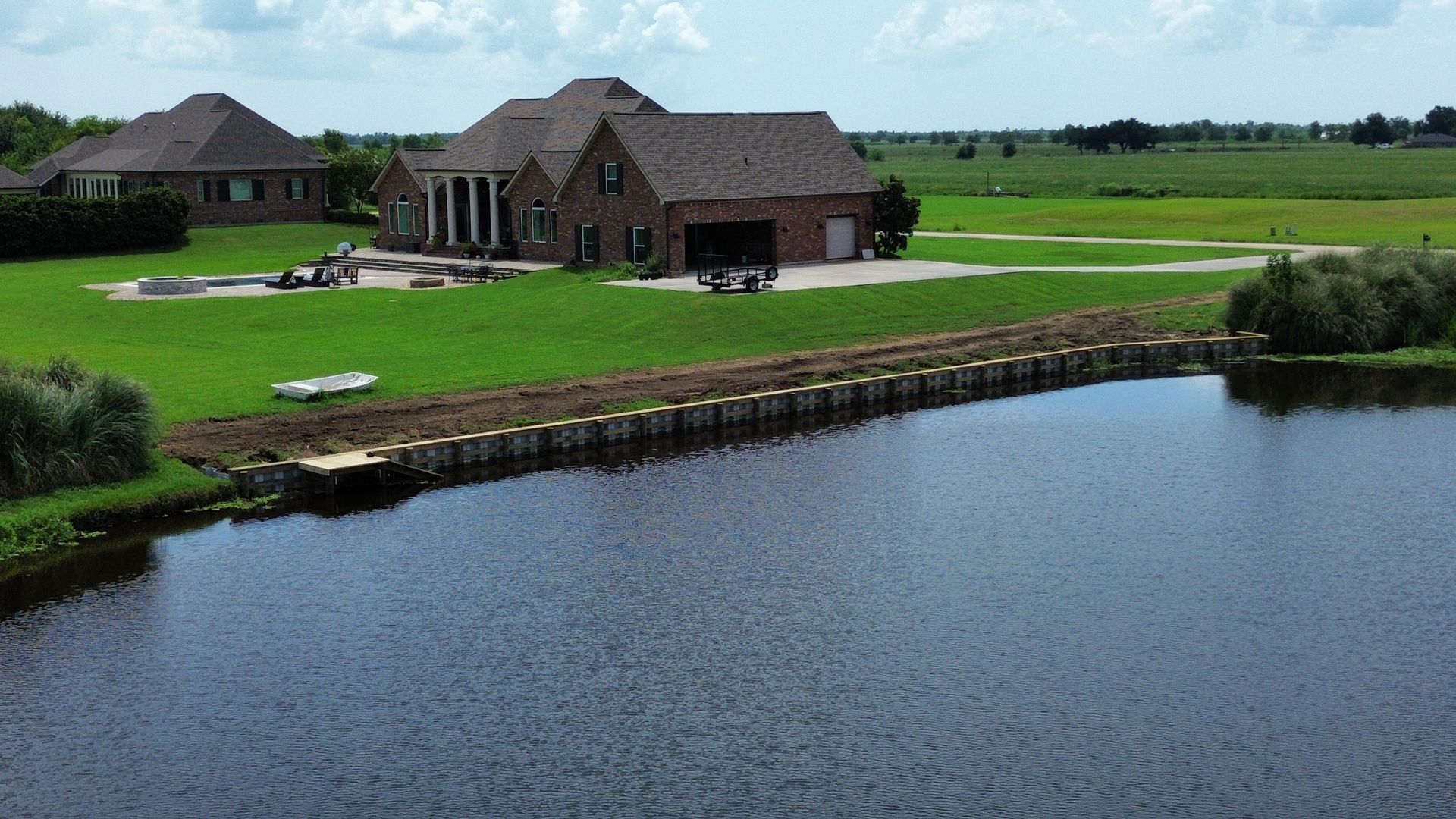 An aerial view of a house next to a body of water