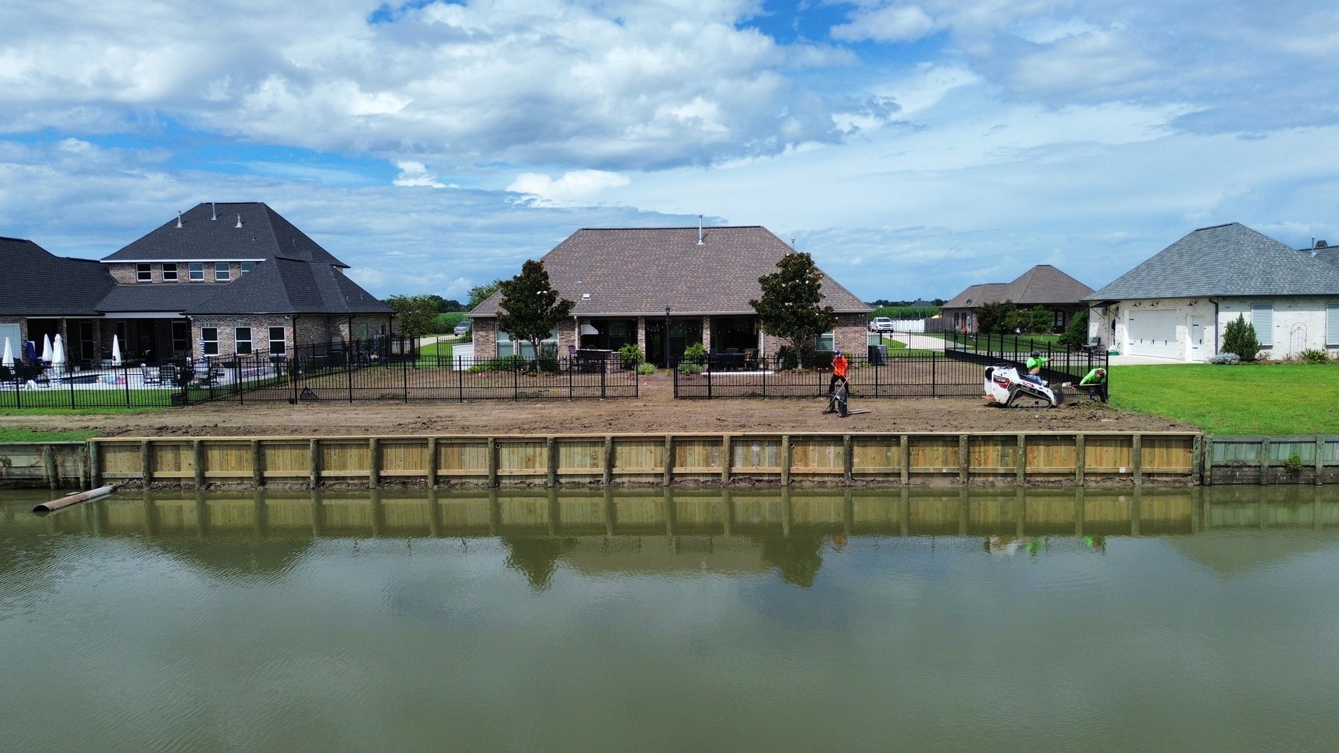 An aerial view of a house next to a body of water.