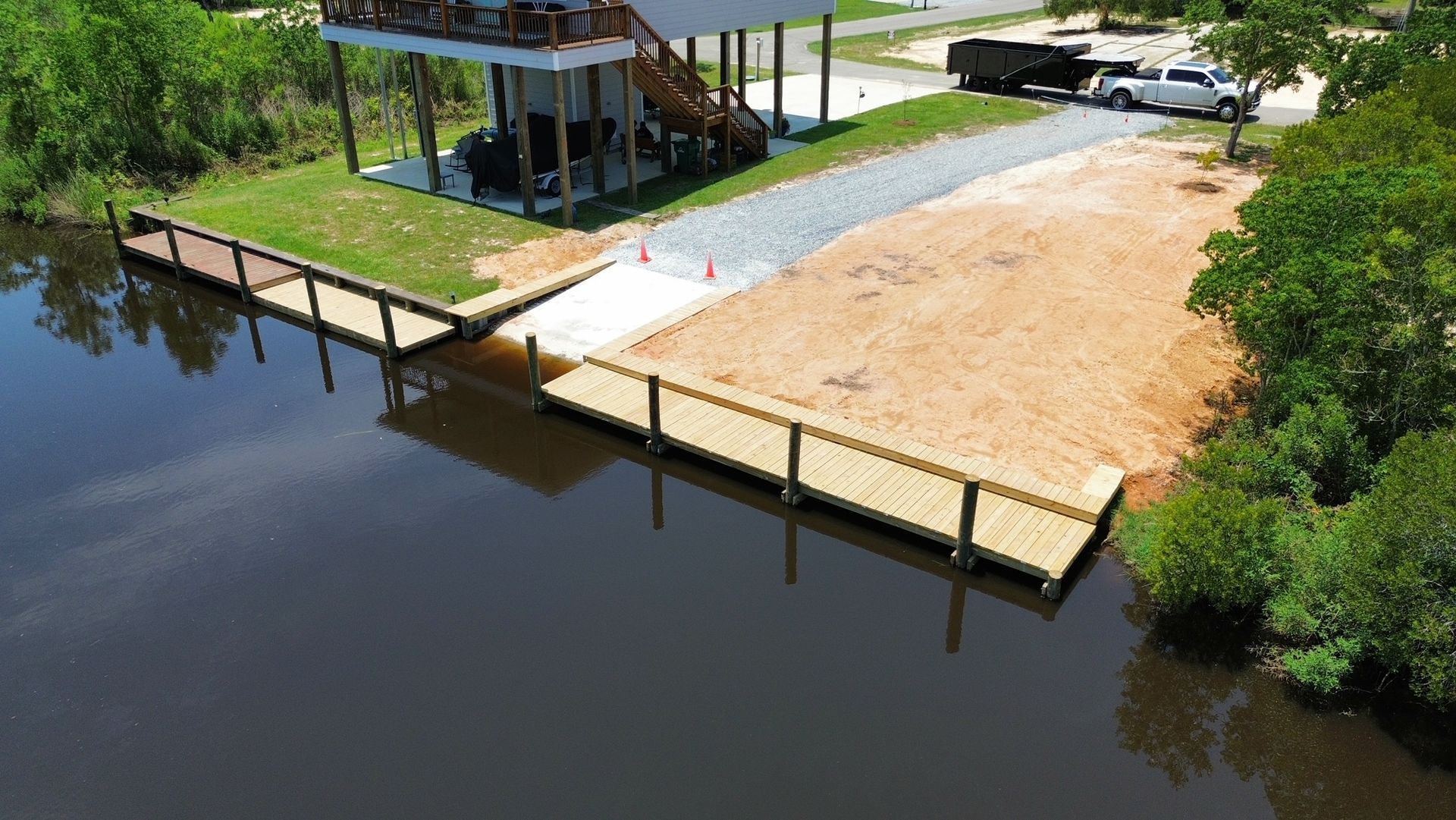 An aerial view of a house next to a body of water with a dock.
