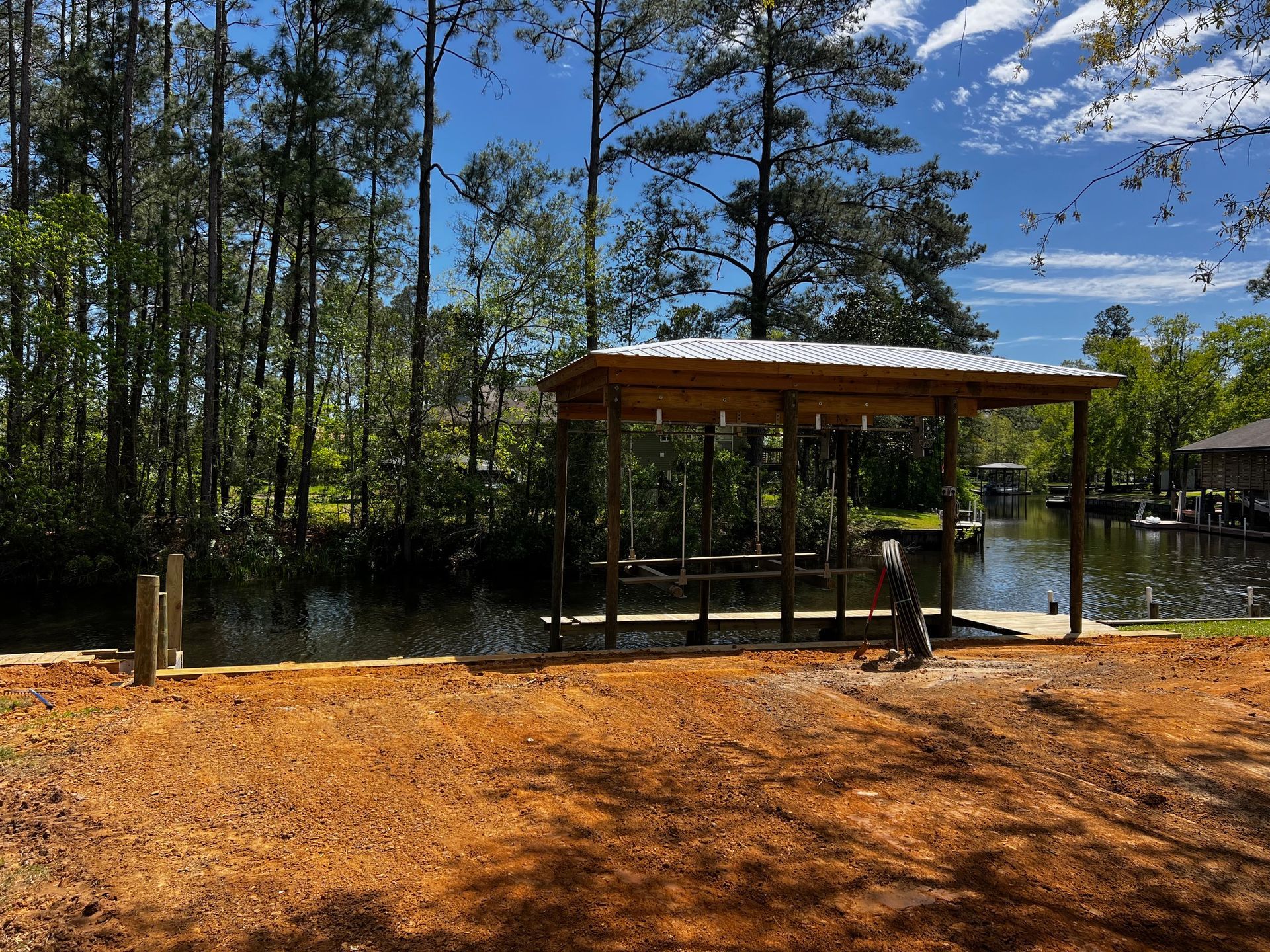 A dock is being built next to a body of water surrounded by trees.