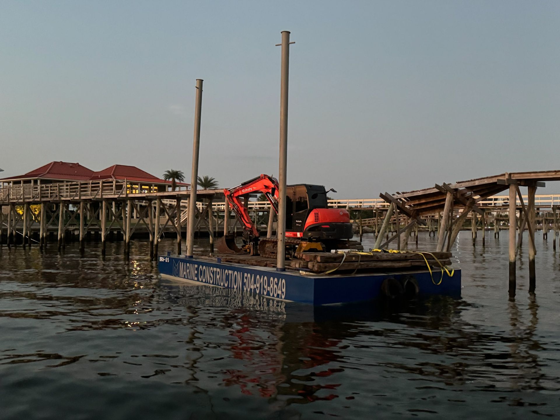 An excavator is on a floating platform in the water