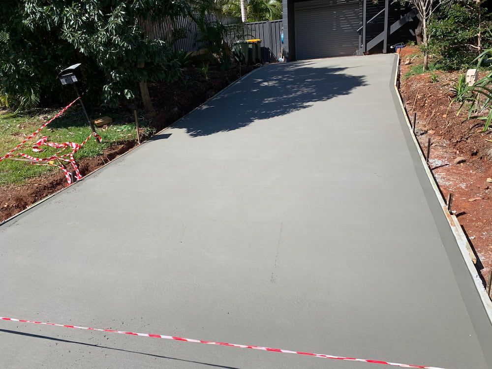 A Concrete Driveway is Being Built in Front of a Garage — Brodie Wynter Concreting in Port Macquarie, NSW