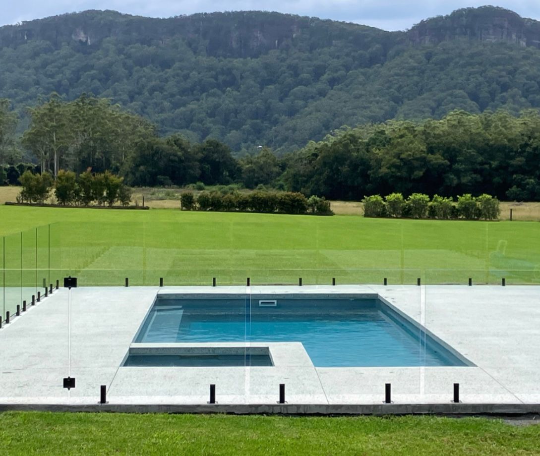 A Large Swimming Pool With Mountains in the Background — Brodie Wynter Concreting in Port Macquarie, NSW
