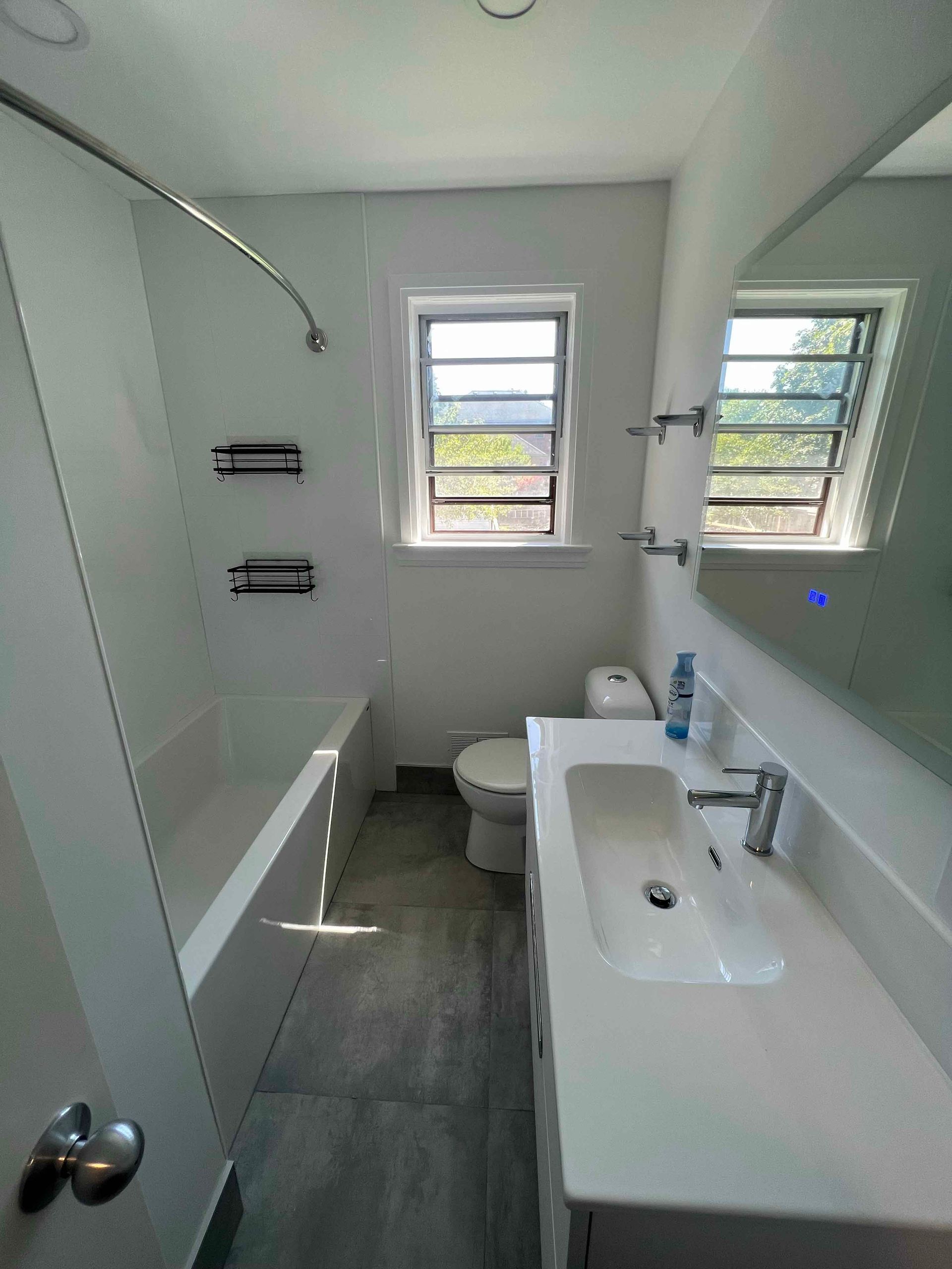A bathroom with a sink , toilet , tub and mirror.