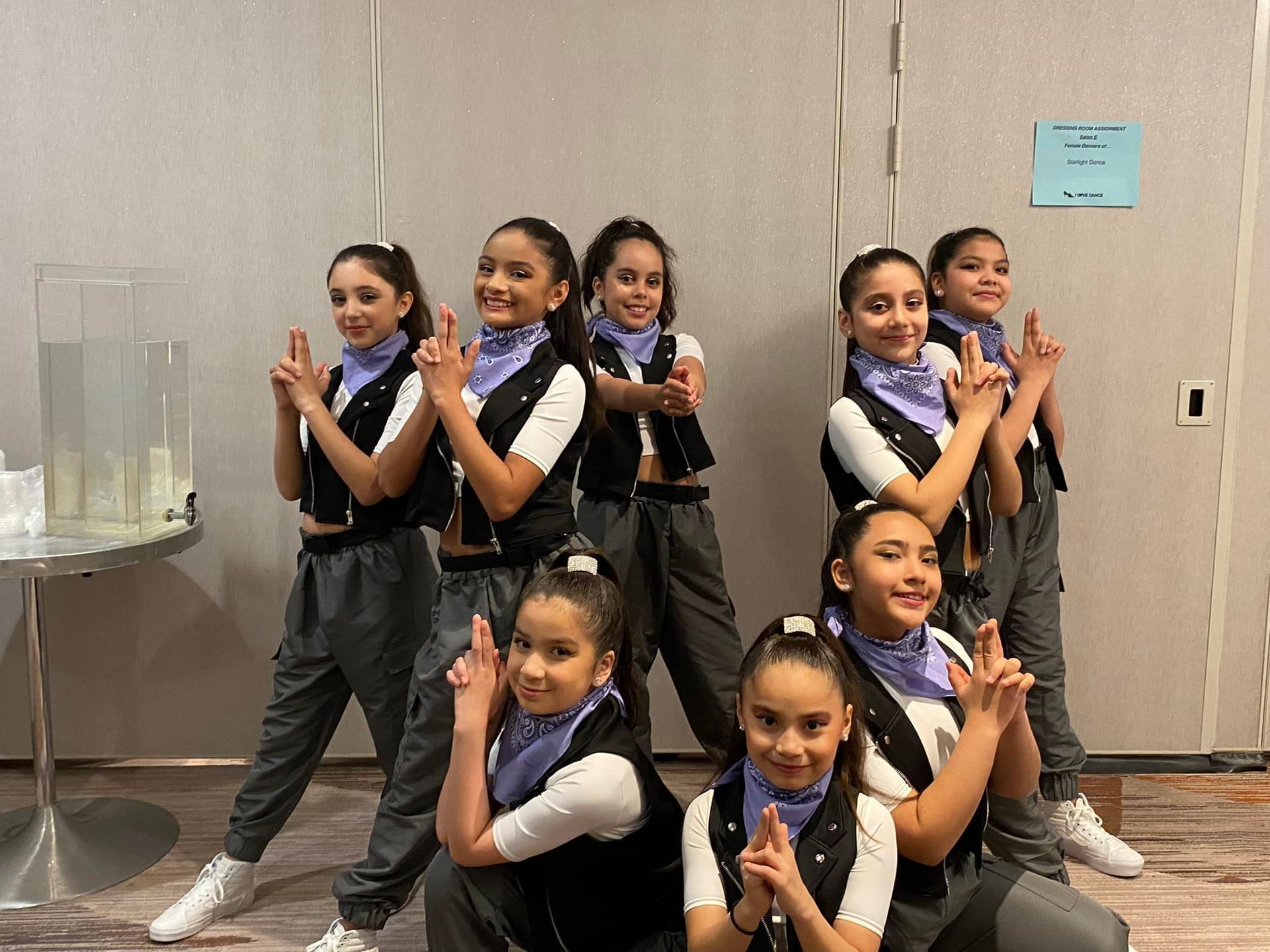 A group of young girls are posing for a picture in a room.