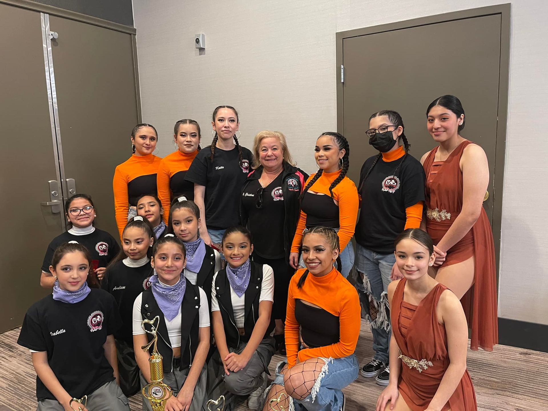 A group of young girls are posing for a picture in a room.