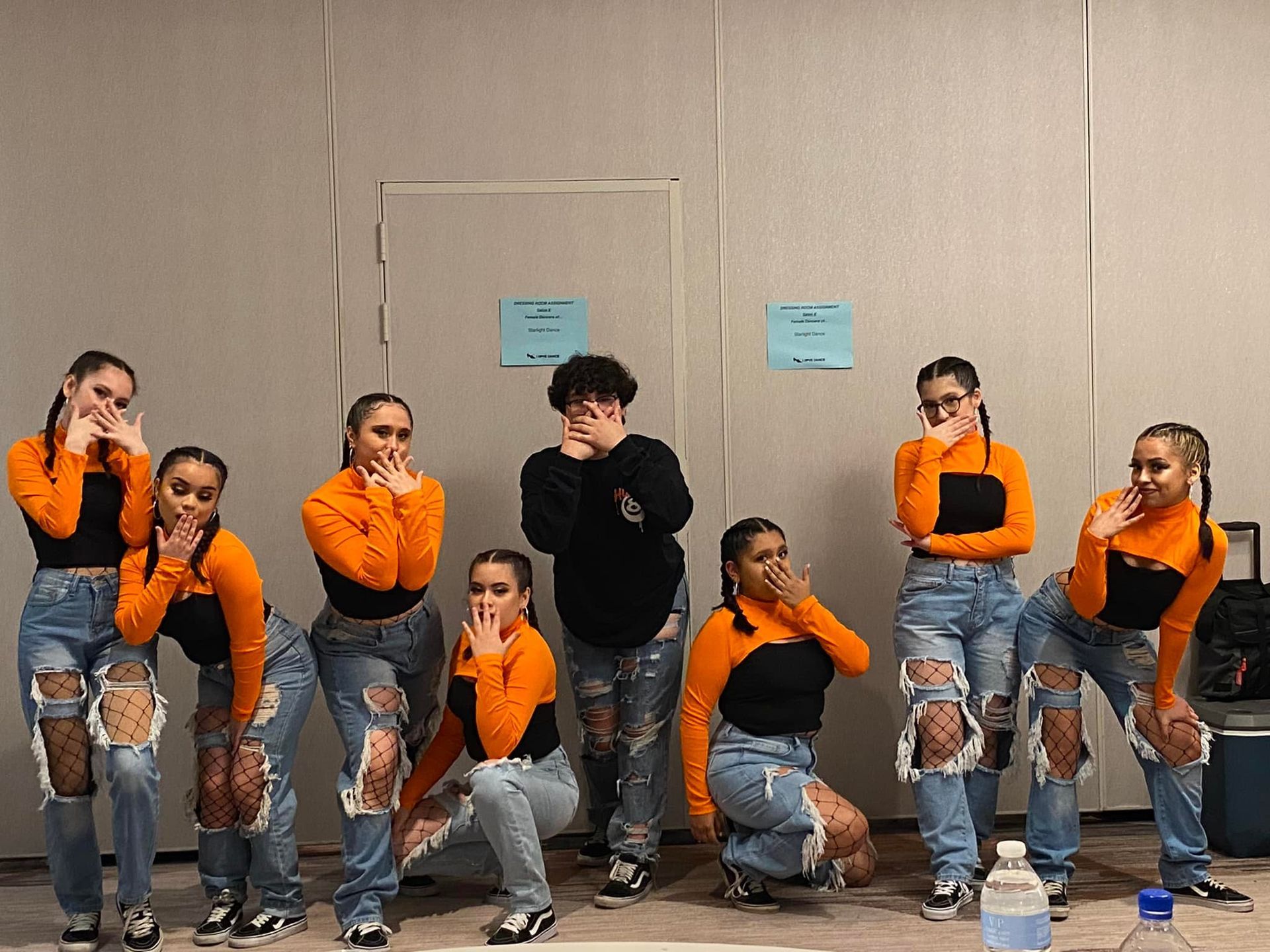 A group of young people are posing for a picture in a room.