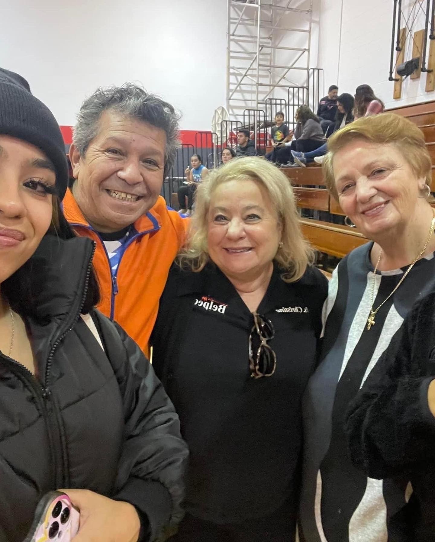 A group of people are posing for a picture in a gym.