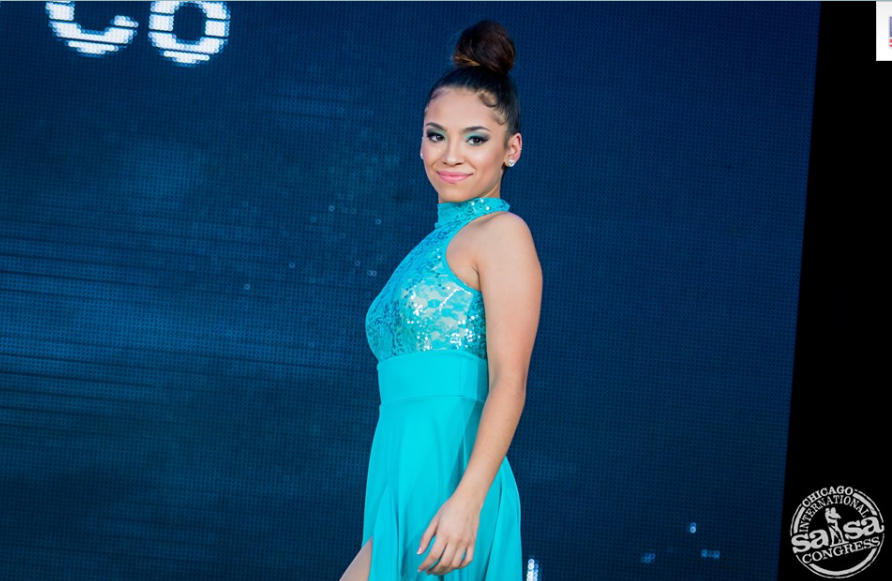 A woman in a blue dress with a bun on her head