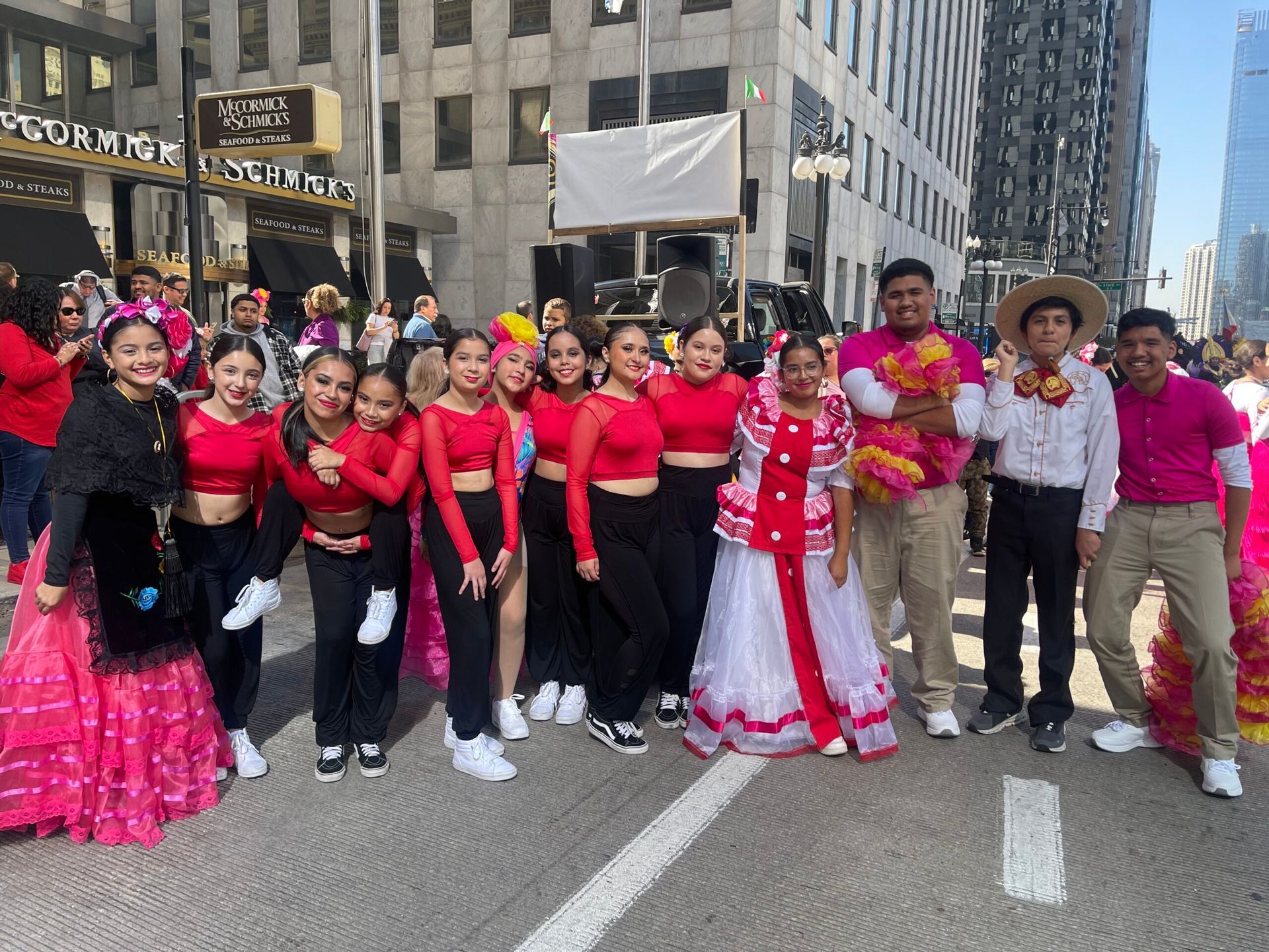 A group of people are posing for a picture on a city street.